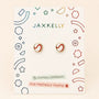 A pair of JaxKelly Softball Enamel Flat Back Kids Earrings, featuring a red and white circular design, are displayed on a card labeled Hypoallergenic and Kid-Friendly Posts with colorful geometric decorations. Crafted from surgical-grade stainless steel, these earrings provide both safety and style for kids with sensitive ears.