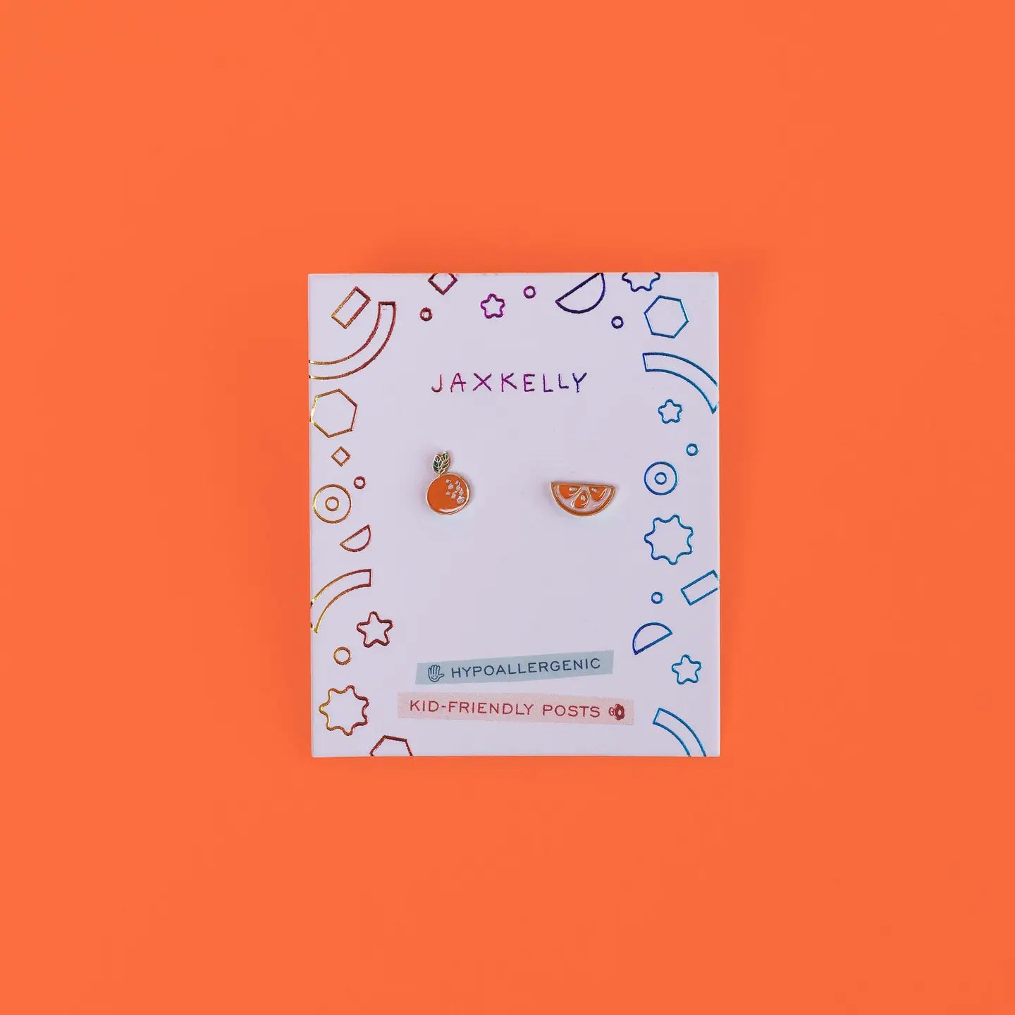 Orange Enamel Flat Back Kids Earrings for sensitive ears on a white card with colorful geometric designs; the card reads JaxKelly, Hypoallergenic, and Kid-friendly posts against an orange background.