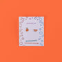 Orange Enamel Flat Back Kids Earrings for sensitive ears on a white card with colorful geometric designs; the card reads JaxKelly, Hypoallergenic, and Kid-friendly posts against an orange background.