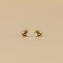 The Bumble Bee Enamel Flat Back Kids Earrings feature small bee-shaped studs with yellow and black stripes and white wings, hypoallergenic for sensitive ears, shown on a plain beige background.