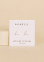 JaxKelly’s Mother of Pearl Mini Energy Gems - Calming are triangle-shaped, gold-trimmed studs with 18k gold plating and sterling silver posts, shown on a branded card against a beige background.