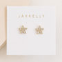 JaxKelly Pavé Flower earrings feature gold flower-shaped studs with sparkling crystals and sterling silver posts, presented on a white card with JaxKelly in gold lettering at the top.