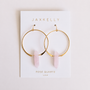 The JaxKelly Rose Quartz Hoop - Love earrings feature gold plated hoops with rose quartz crystal pendants, displayed on a white card with gold “JAXKELLY” and “ROSE QUARTZ Love” text.