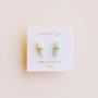A pair of light green amazonite mineral point earrings, wrapped in 18k gold by JaxKelly, shown on a white card labeled "JaxKelly Amazonite Mineral Point - Hope" in gold text, set against a light beige background.