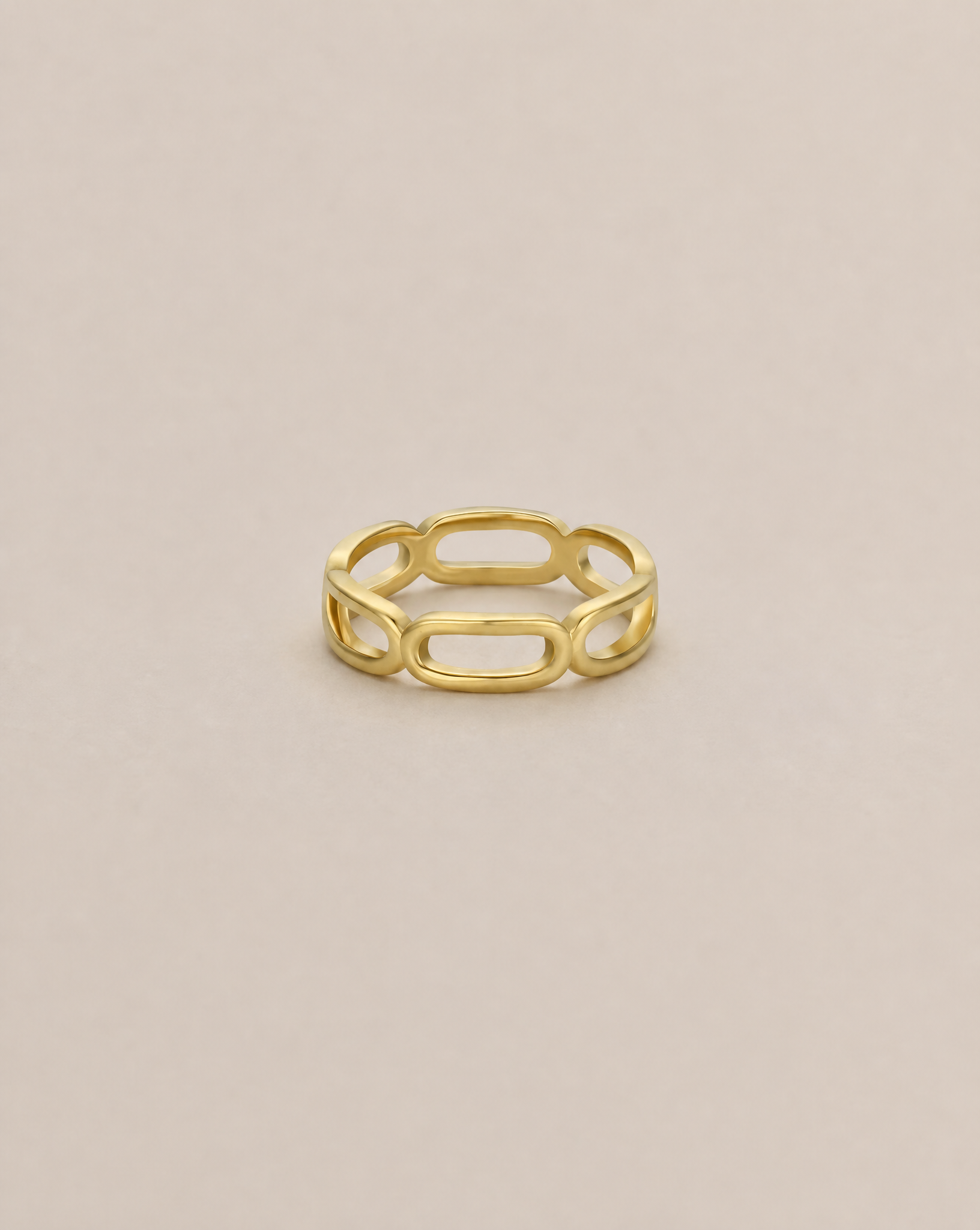 The JaxKelly Chain Link Gold Ring features an open oval link design, ideal for stacking, and is shown on a plain light beige background.