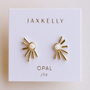 Sun Ray - White Opal stud earrings by JaxKelly feature gold sun ray designs with opal centers and radiating bars, displayed on a white card—perfect for adding a touch of boho elegance to any look.