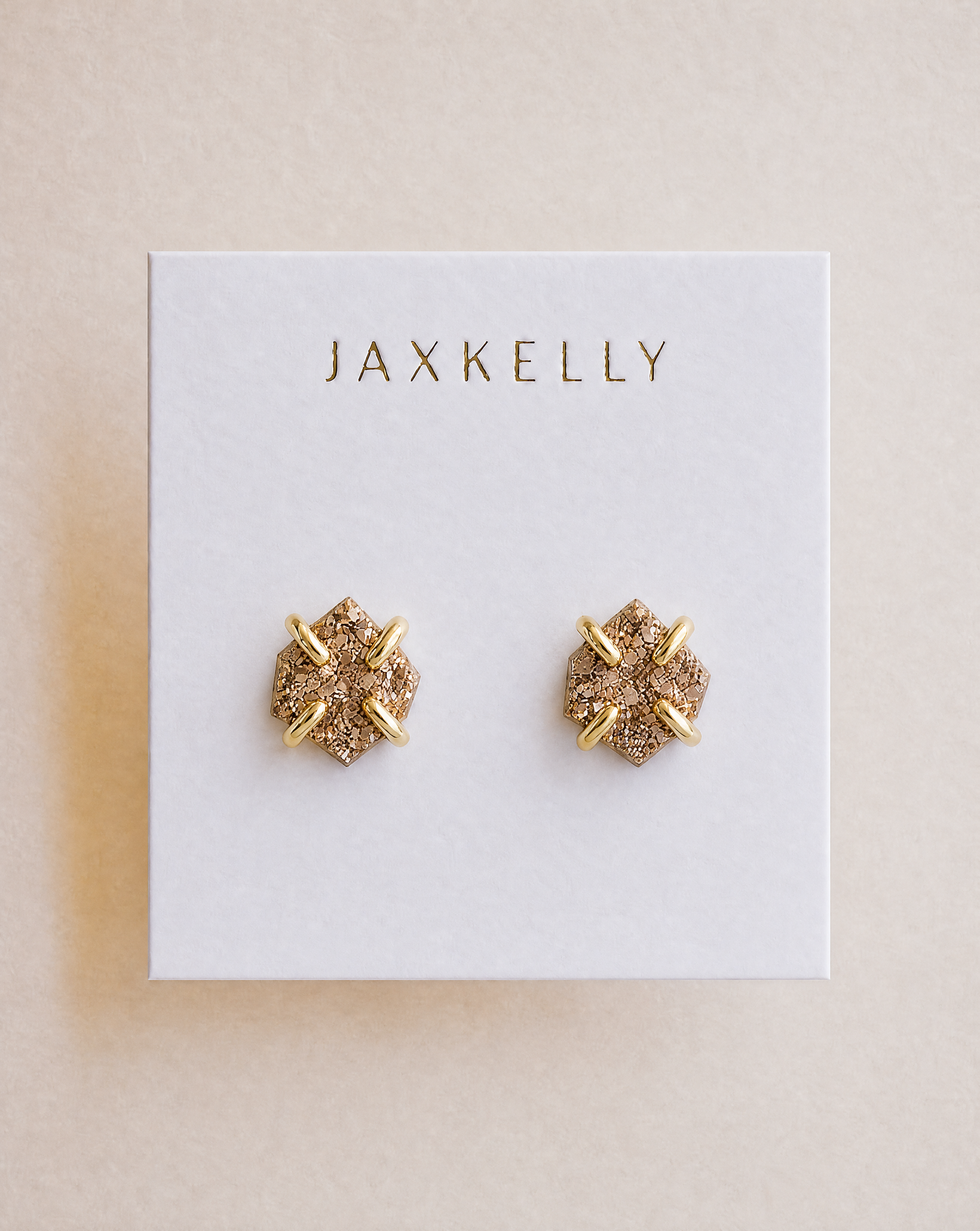 A pair of Rose Gold Druzy Prong stud earrings by JaxKelly featuring a sparkling textured surface and 18k gold plating.