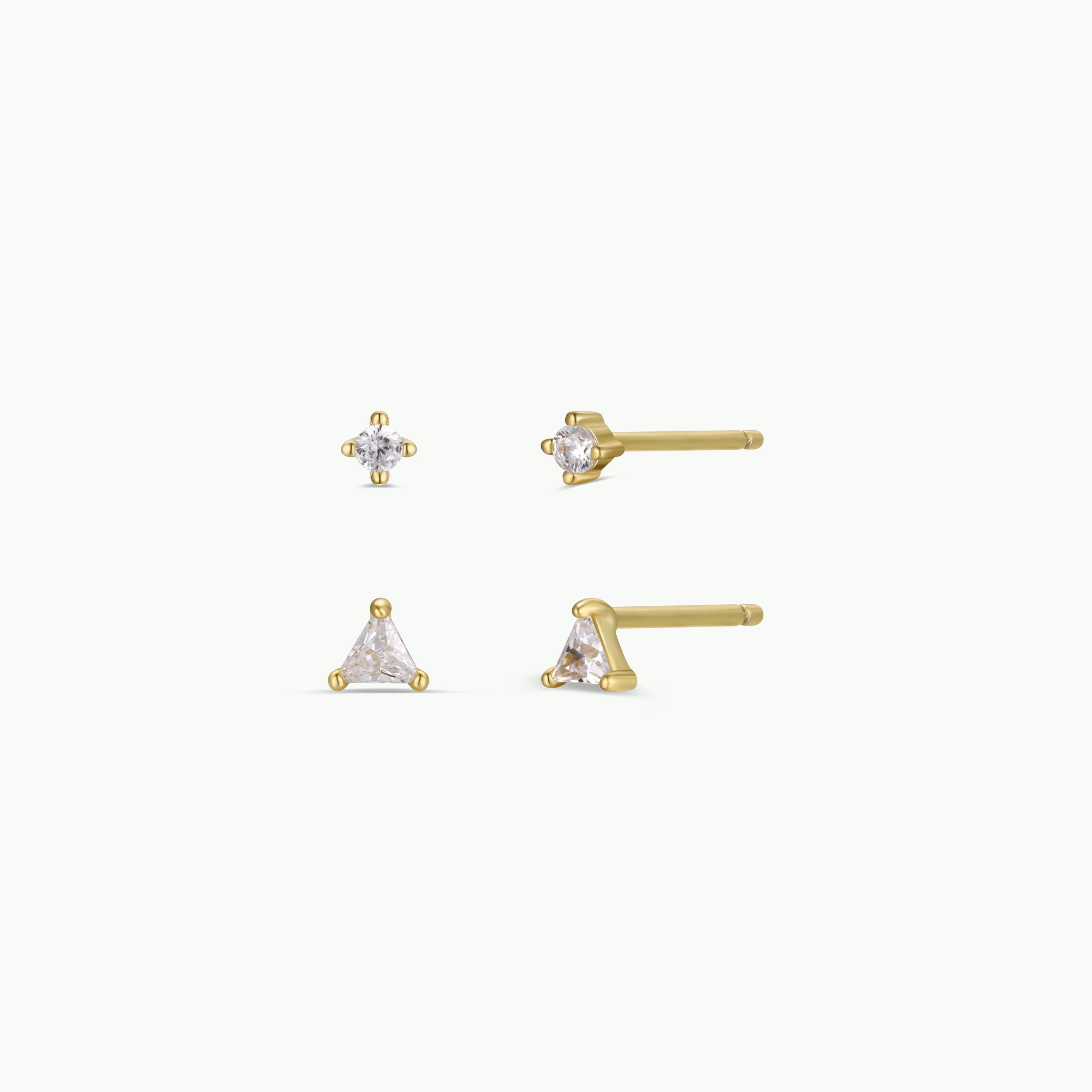 The Birthstone Stud Earring Set - April features gold plated earrings with clear gemstones: one circular with three prongs and one triangular with three prongs, all shown on a plain white background.