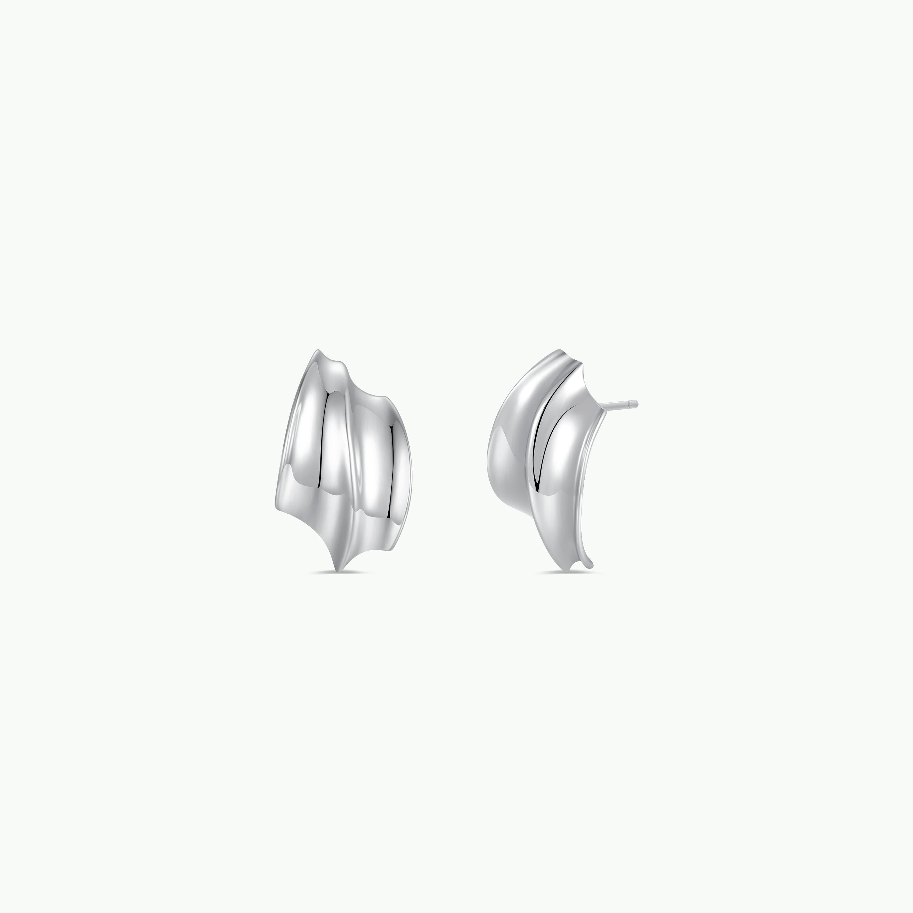 The Bold Wave - Silver Earring by JaxKelly features two modern wave-shaped silver studs with smooth, curved surfaces and sterling silver posts, shown side by side on a plain white background.