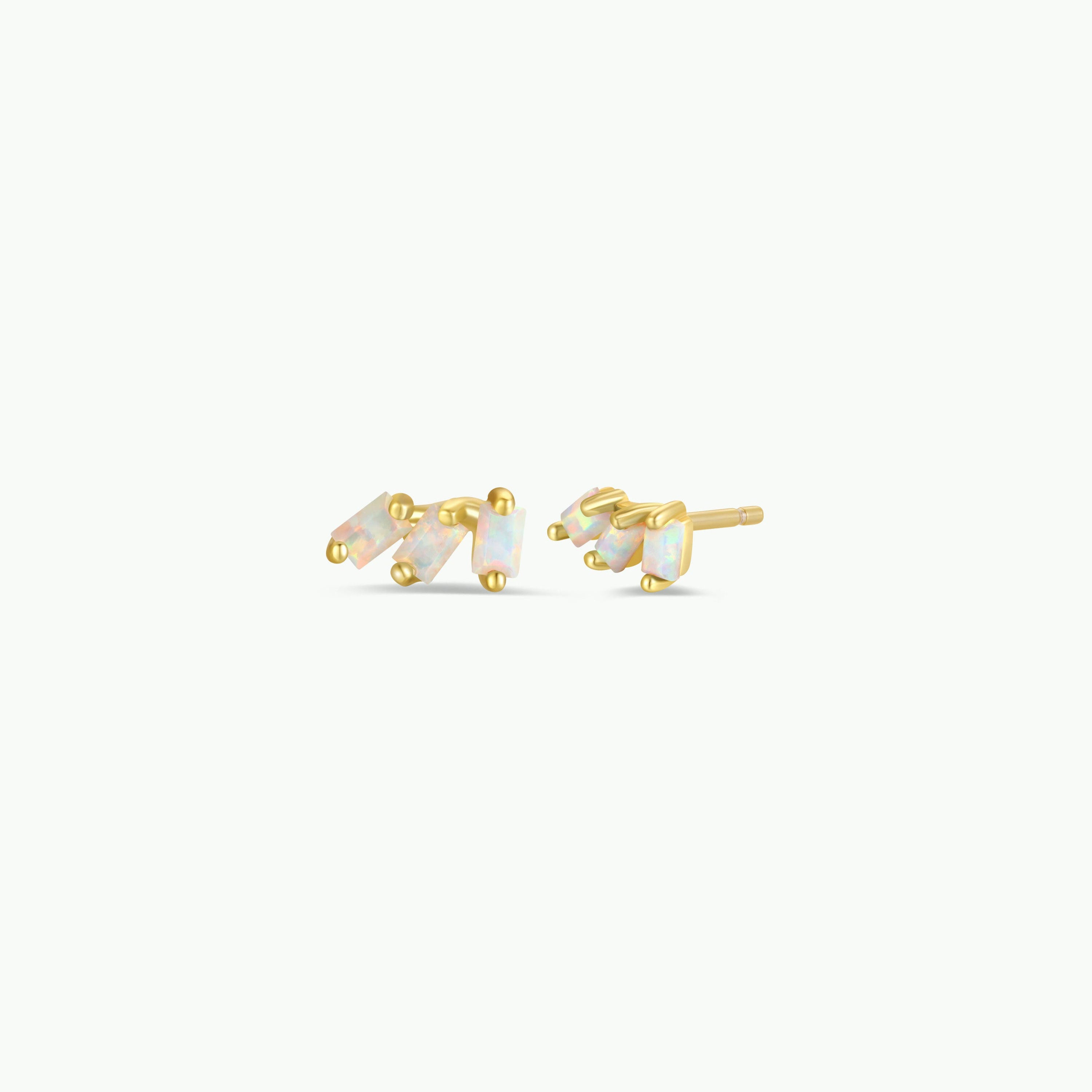 The Offset Trio - White Opal features gold-plated stud earrings, each with three vertically arranged rectangular lab-grown white opal stones in gold prong settings, shown on a plain white background.