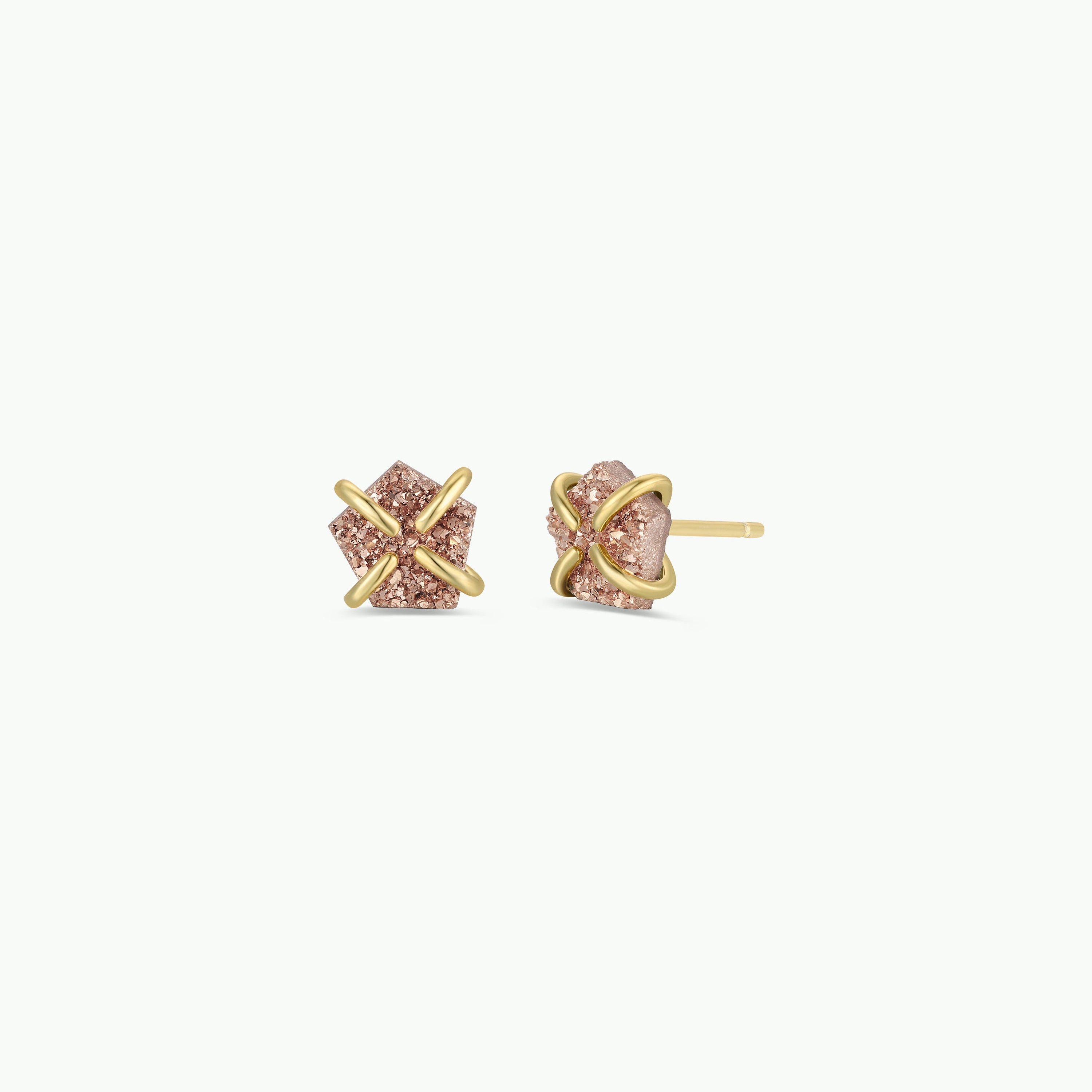 The Rose Gold Druzy Prong earrings feature geometric pink natural druzy stones wrapped with gold X-shaped bands and finished with 18k gold plating, displayed against a plain white background.