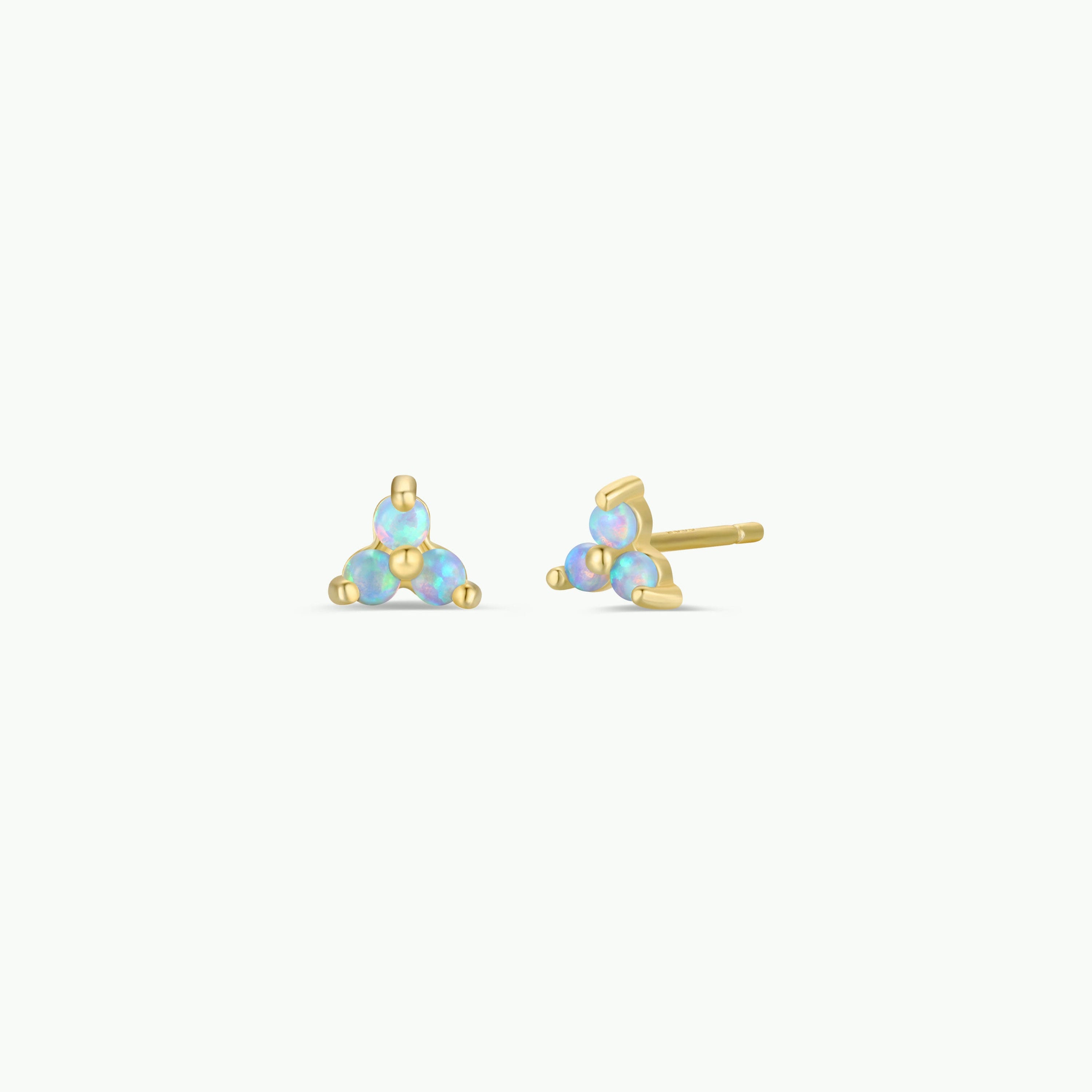 The Trio Cluster Gold Earrings - Fire Opal feature three iridescent lab-grown fire opals in a gold-plated triangular stud design. One earring is upright, the other on its side, both shown against a white background.