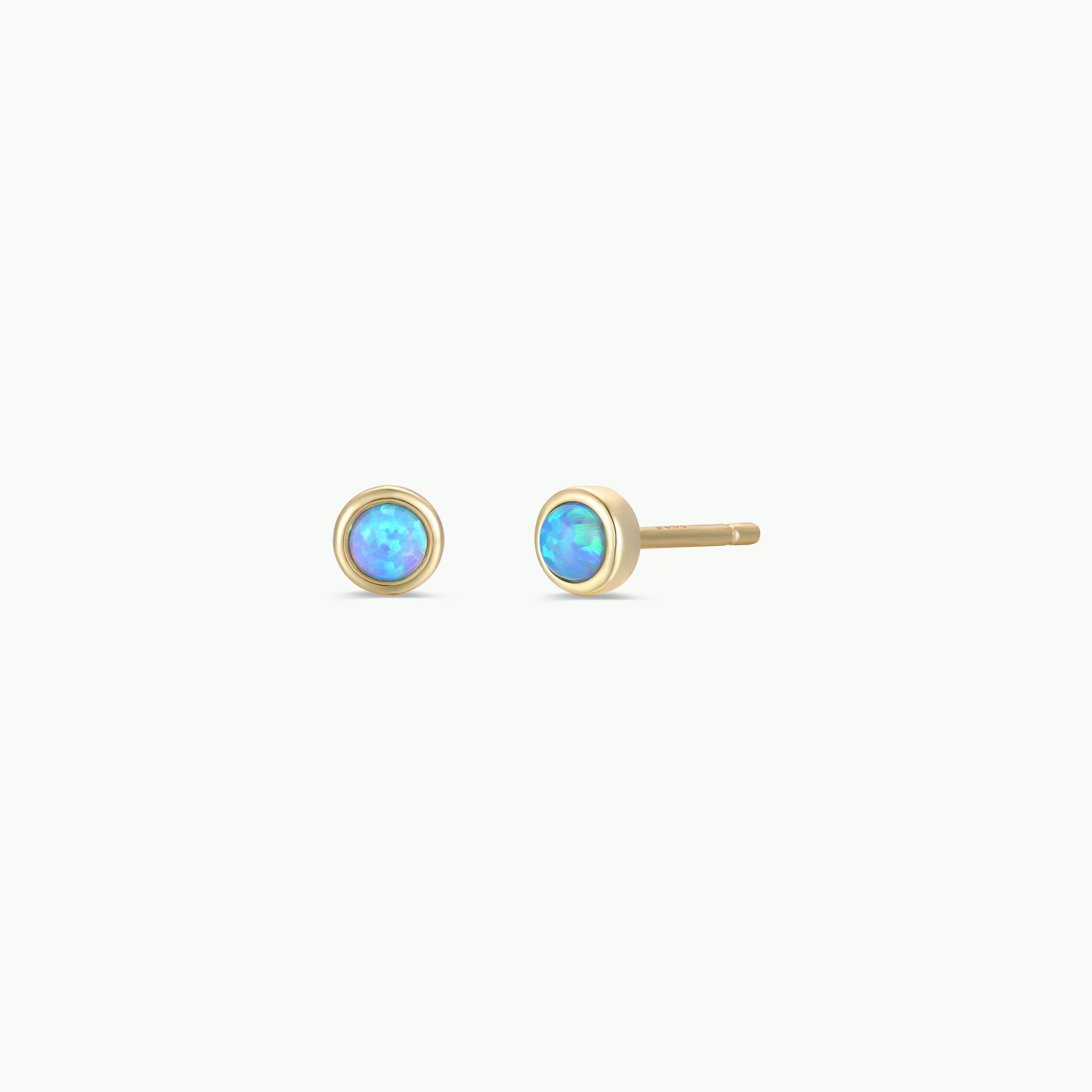 The Simple Stud Earring - Fire Opal features a pair of small 18k gold plated studs, each adorned with a round lab-grown fire opal gemstone, shown on a plain white background.