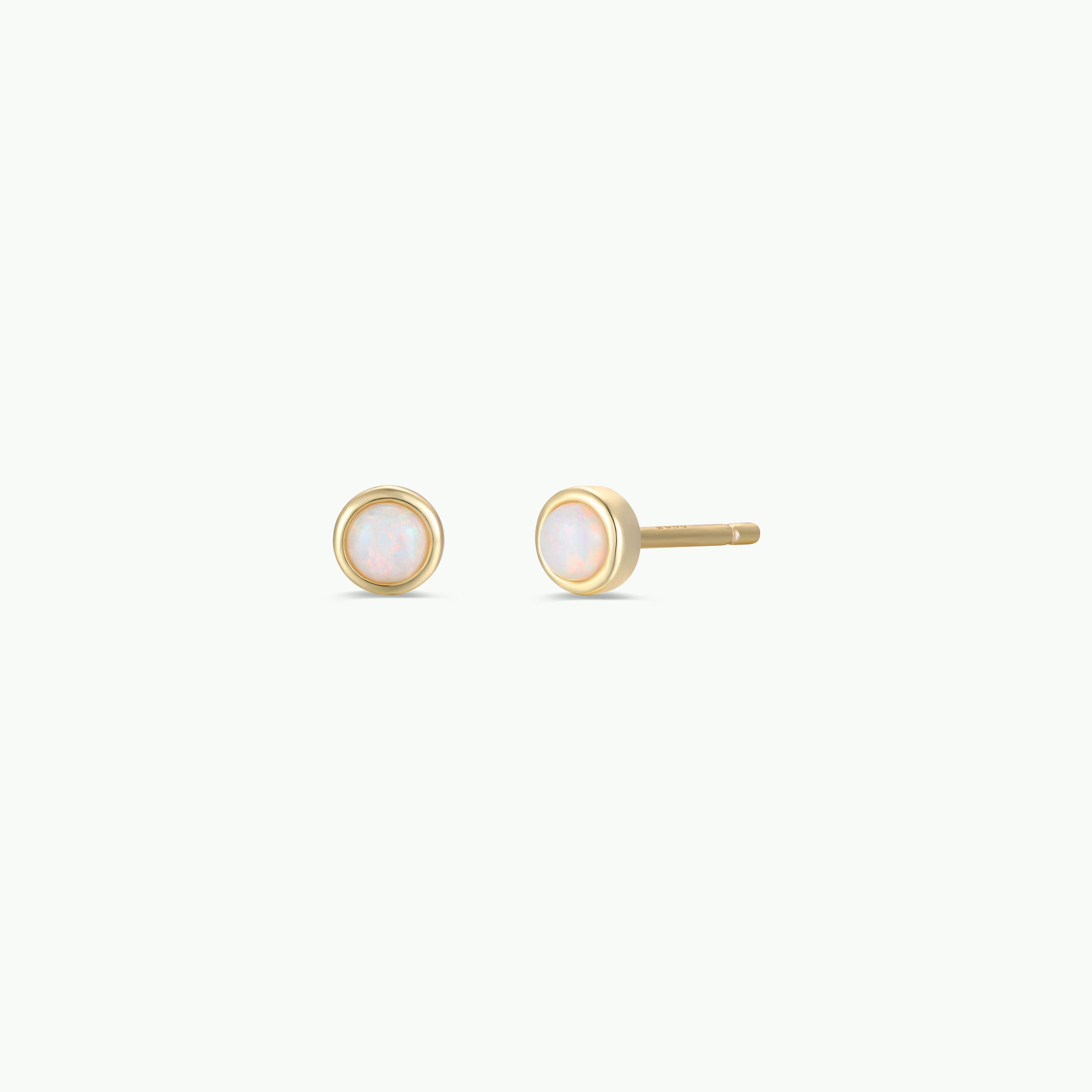 The Simple Stud - White Opal earrings are 18k gold plated with round lab-grown white opals in smooth bezels, displayed against a plain white background.