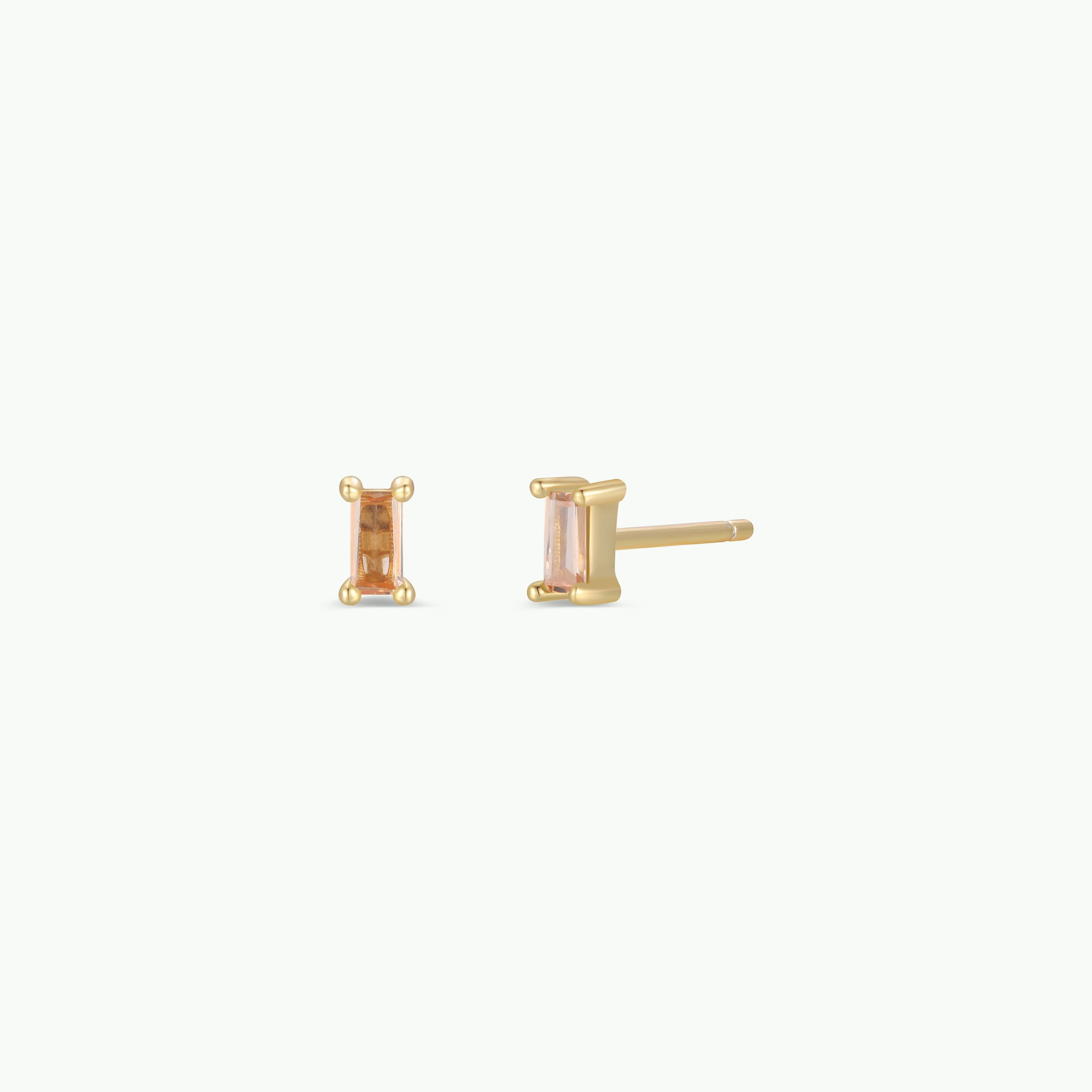 Champagne Baguette: Gold plated baguette stud earrings with rectangular light pink gemstones in four-prong settings and sterling silver posts, shown on a plain white background.