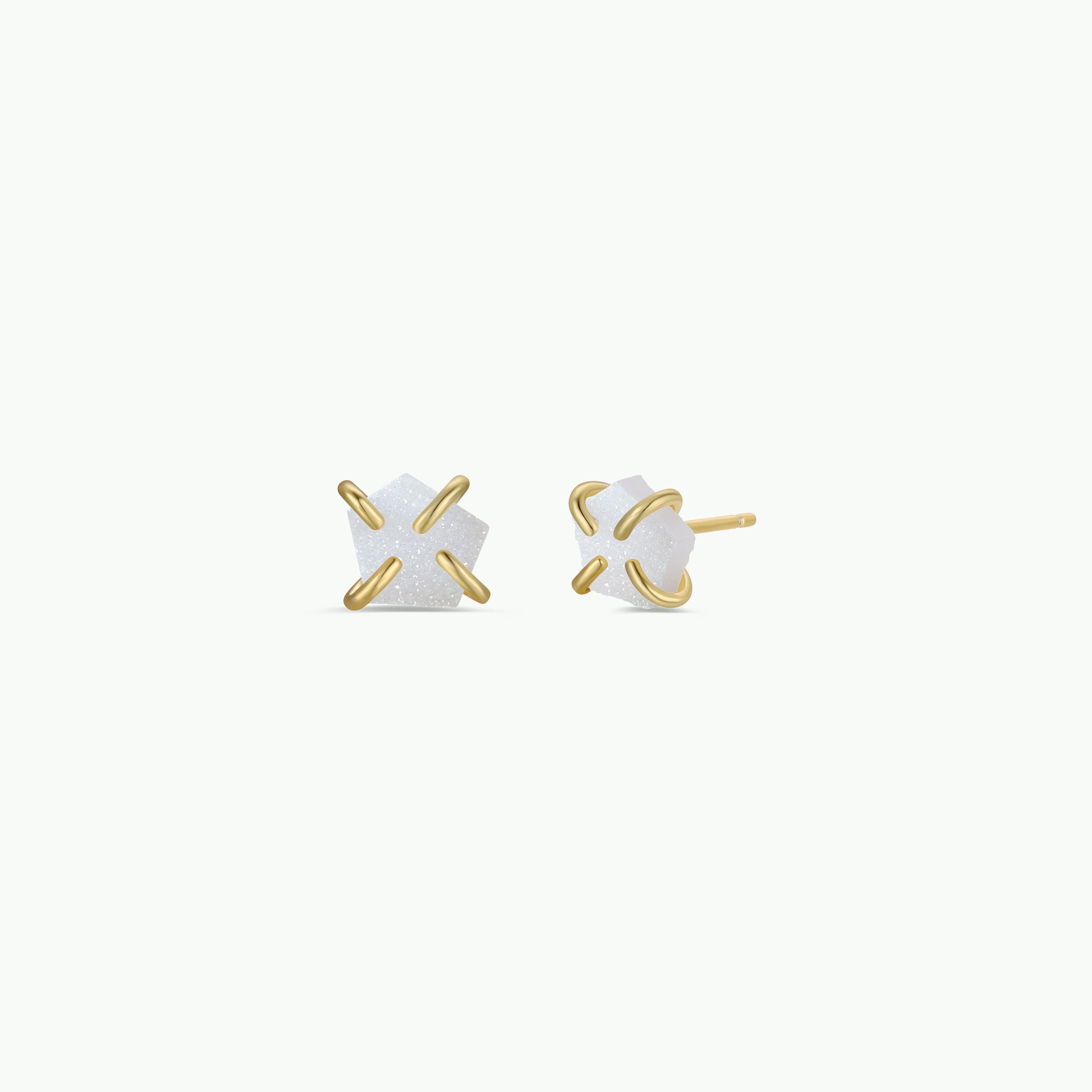 The White Druzy Prong stud earrings feature small white geometric natural druzy stones set in 18k gold plating; one faces forward and one is shown from the side with post, both on a plain white background.