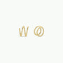 The Minimalist Spiral features two sterling silver rings with 18k gold plating, shaped like the lowercase letters “w” and “o,” displayed on a plain white background.