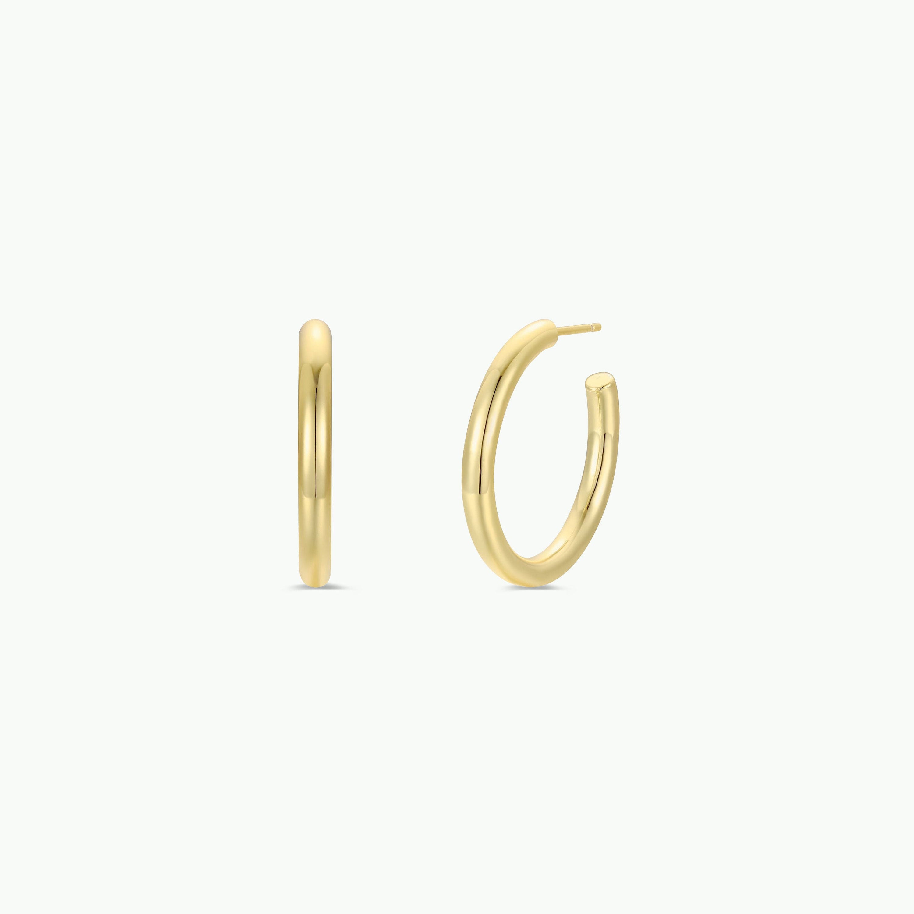 The Gold Everyday Hoop - Medium is displayed on a white background, with one earring facing forward and the other sideways to highlight its thickness and clasp—an ideal pick for lovers of classic, timeless jewelry.