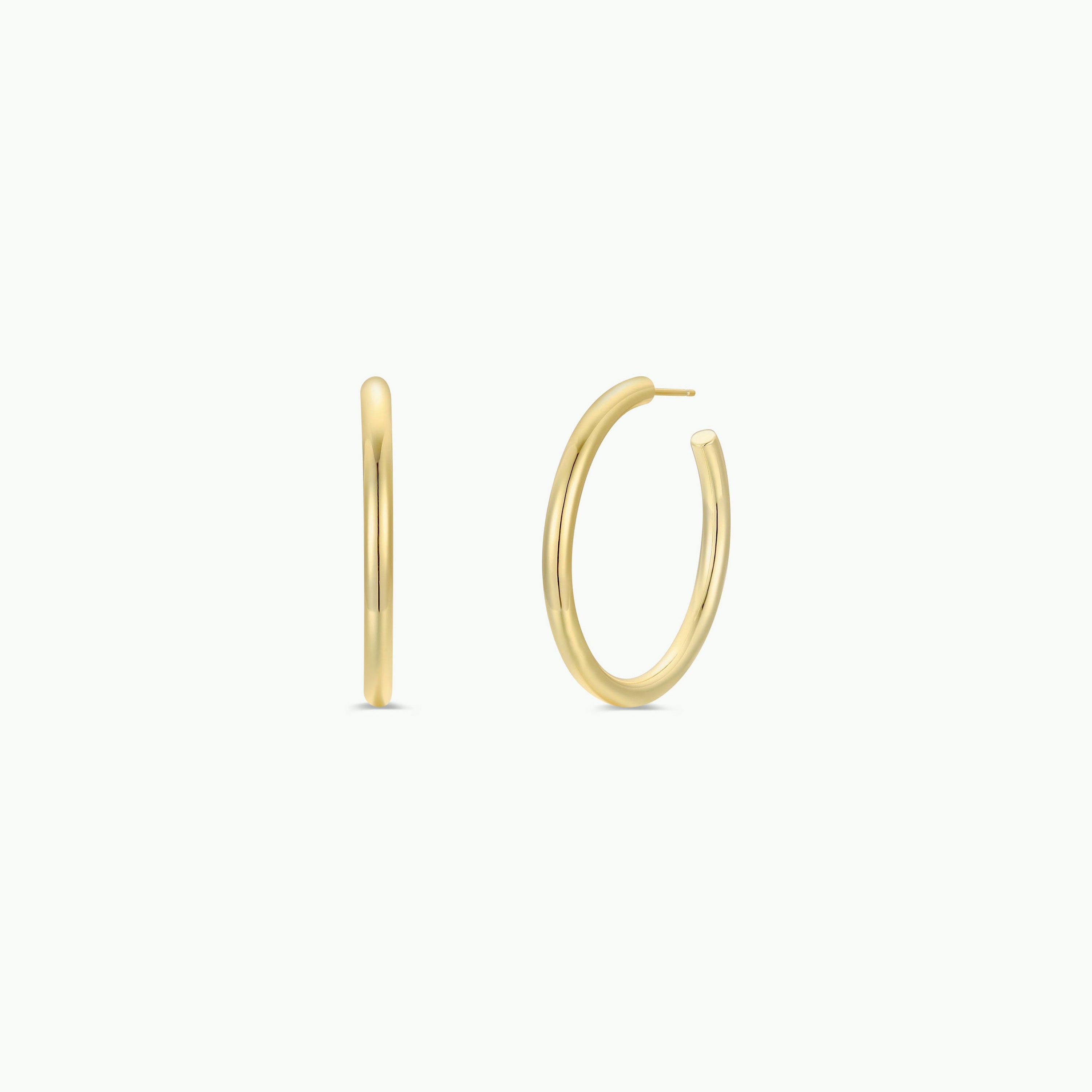 The Gold Everyday Hoop - Large features two simple 18k gold plated earrings on a clean white background, shown from front and side angles to highlight their smooth, minimalist design—a timeless jewelry essential.