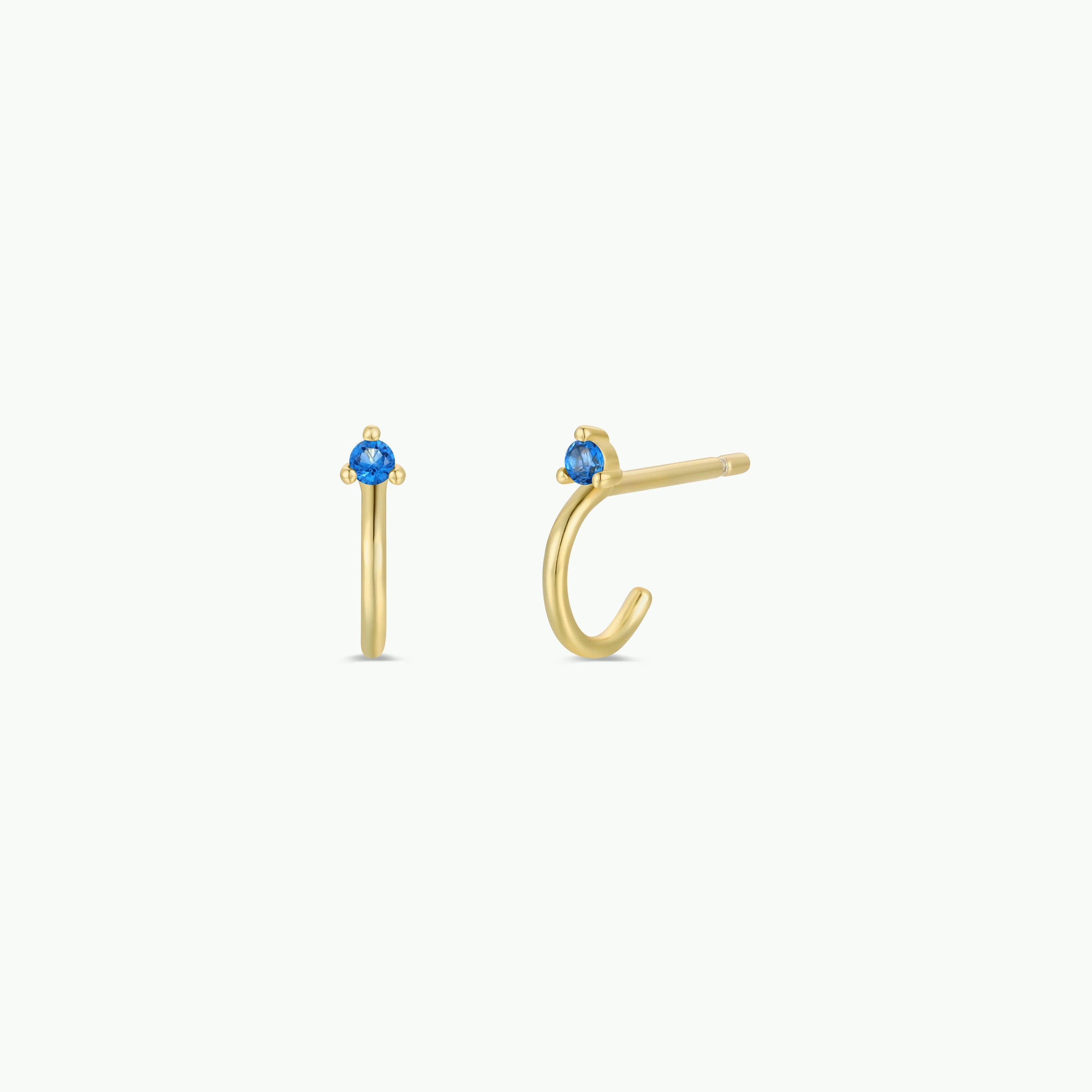 A pair of Open Mini Hoop Earrings - Blue Sapphire, plated in 18K gold and adorned with small sapphire CZ stones at the top, shown on a plain white background.