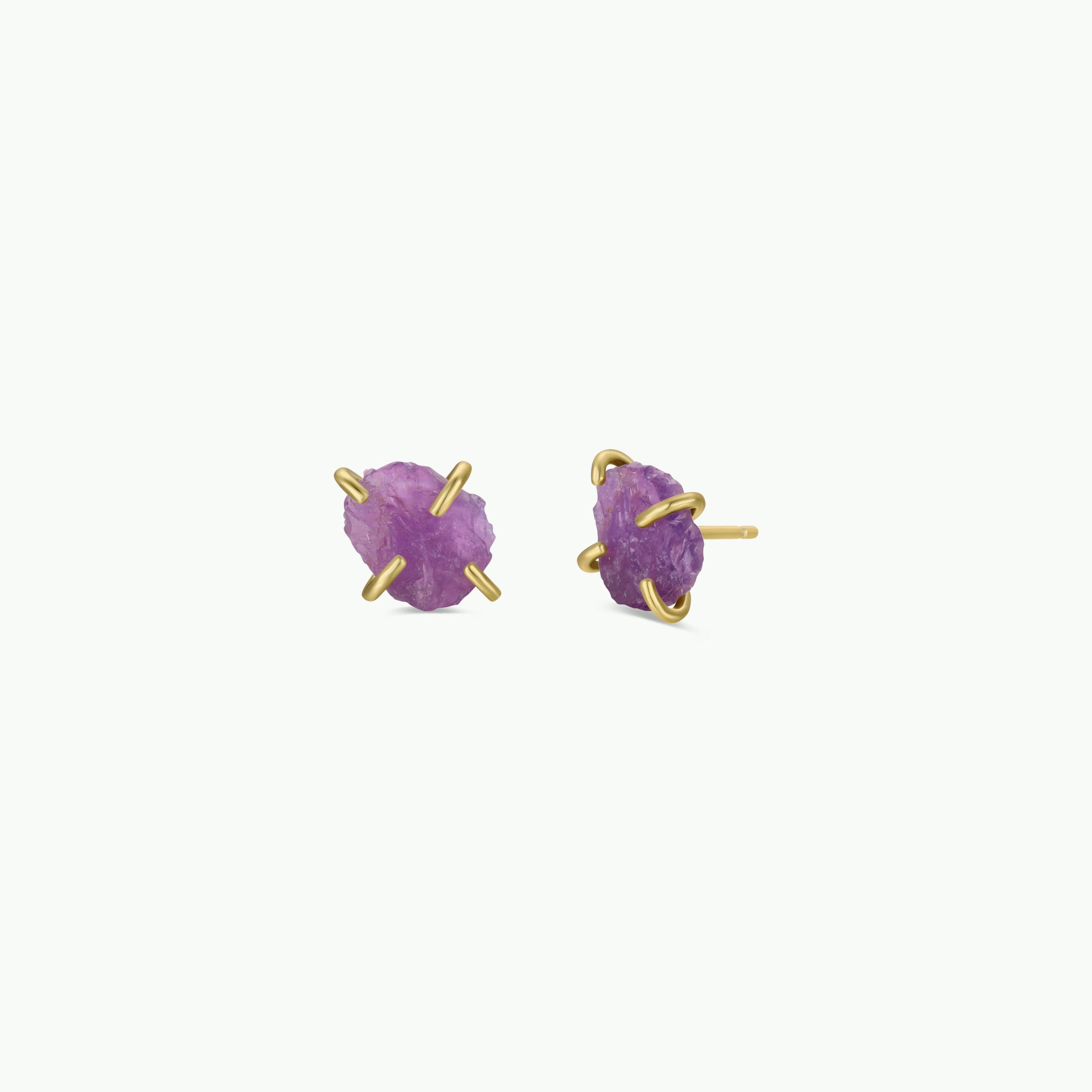 The Amethyst Gemstone Prong - Healing stud earrings showcase rough-cut amethyst stones secured by gold prongs, set against a plain white background.