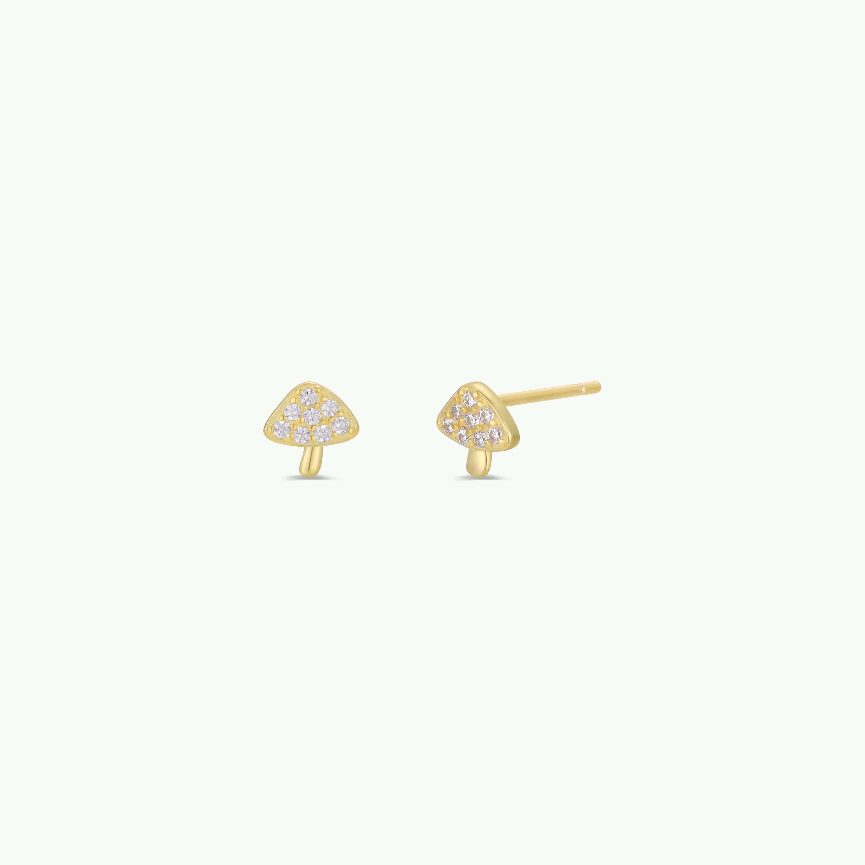 The Pavé Mushroom features small gold plated mushroom earrings, each with tiny CZ stones on the cap. They are shown against a plain white background.