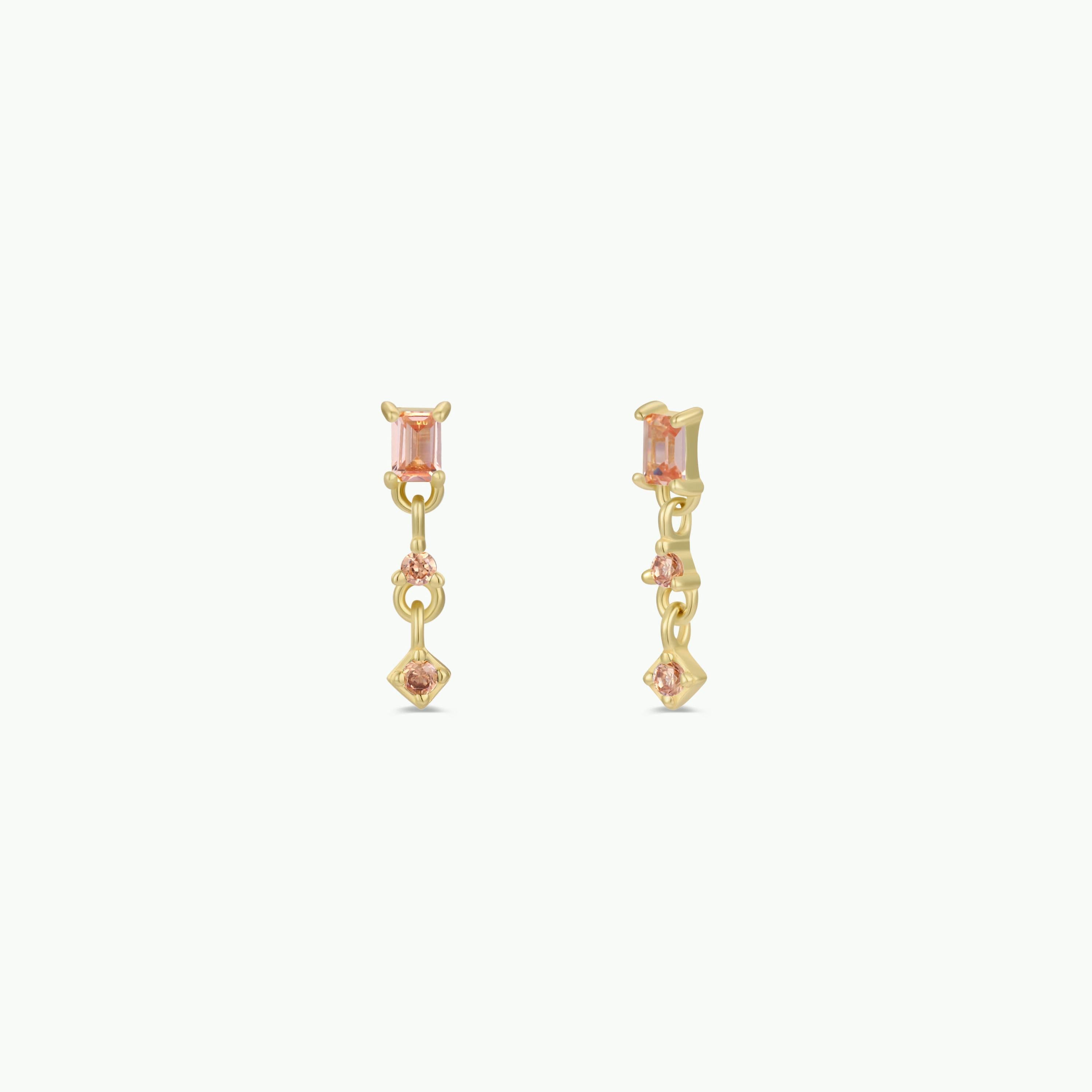 The Mini Baguette Drop - Champagne earrings feature gold plating with rectangular champagne-colored stones on top and smaller CZ drops below, displayed against a plain white background.