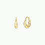 The JaxKelly Sculptural Wide Hoop features bold, smooth, and slightly tapered hoops in tarnish-free 18K gold plating. One earring is closed and the other open, highlighting the unique clasp design against a plain white background.