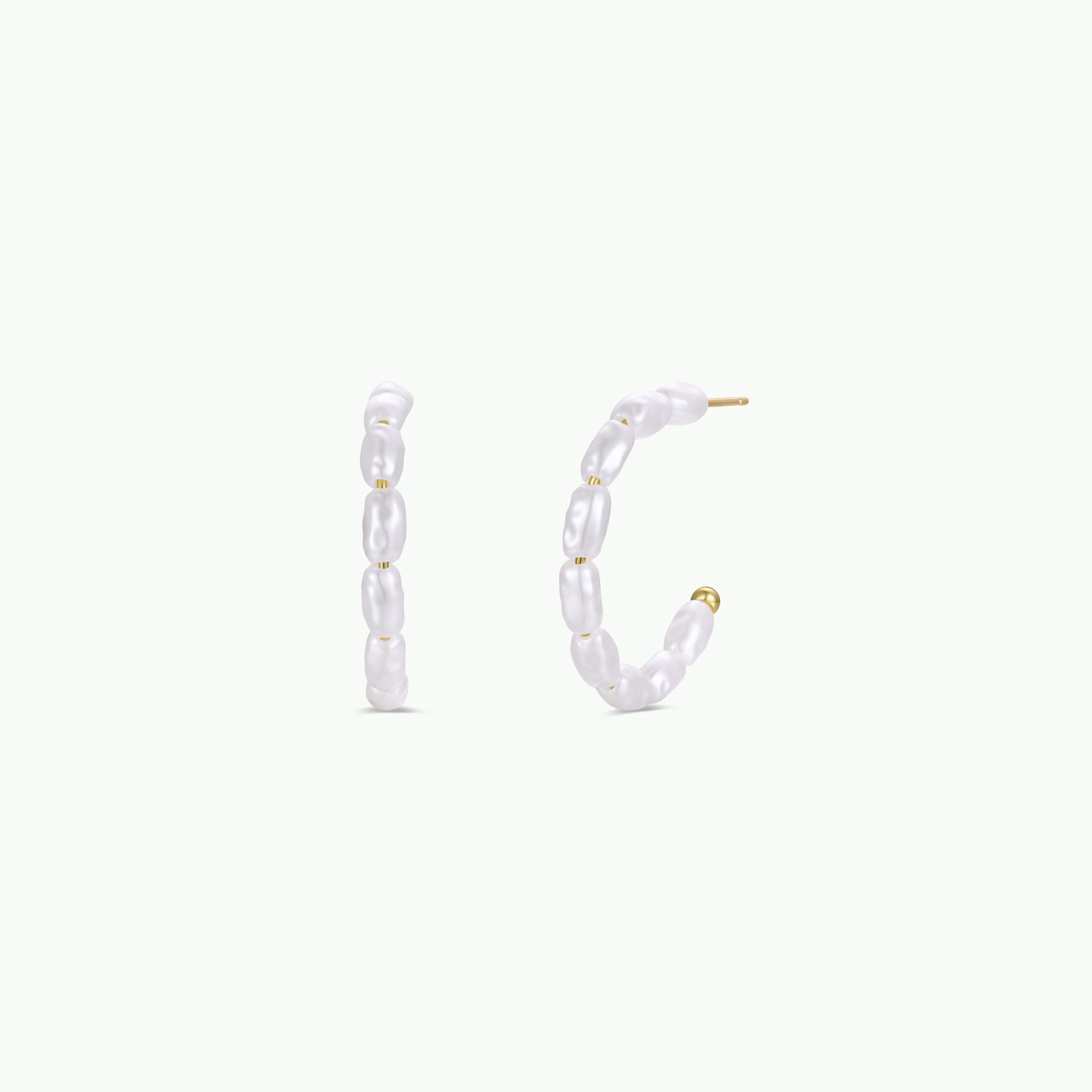 The Multi Pearl Hoop Earrings feature small, uniquely shaped freshwater pearls in a semi-circular gold-plated setting, showcased against a plain white background.