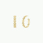 The Daisy Chain Earrings - Enamel and Gold are gold hoop earrings adorned with small daisy designs, displayed from front and side views on a white background.