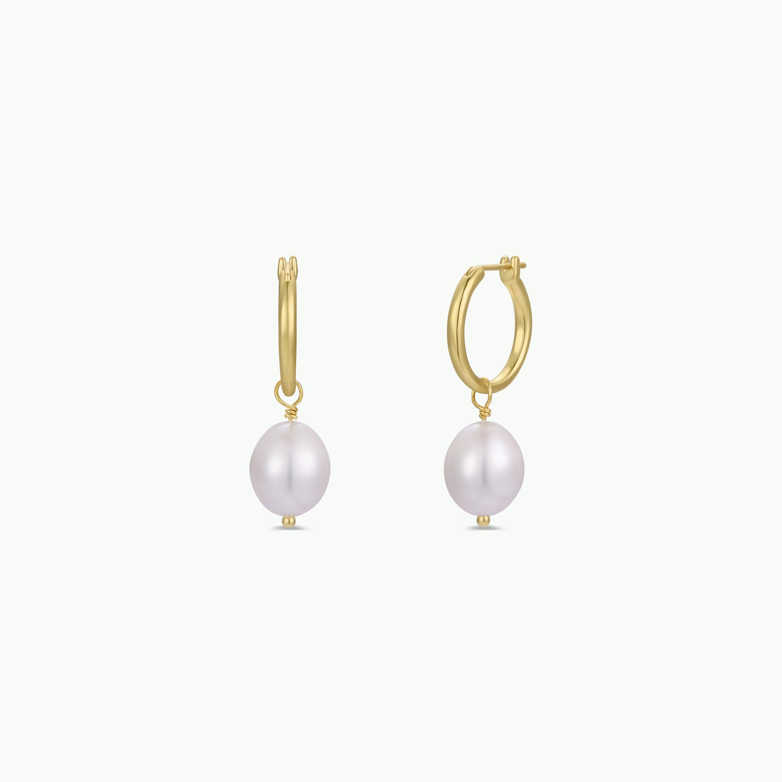 The Pearl Drop Earring features gold plated hoops with sterling silver posts and a single round freshwater pearl dangling from each, shown on a plain white background.