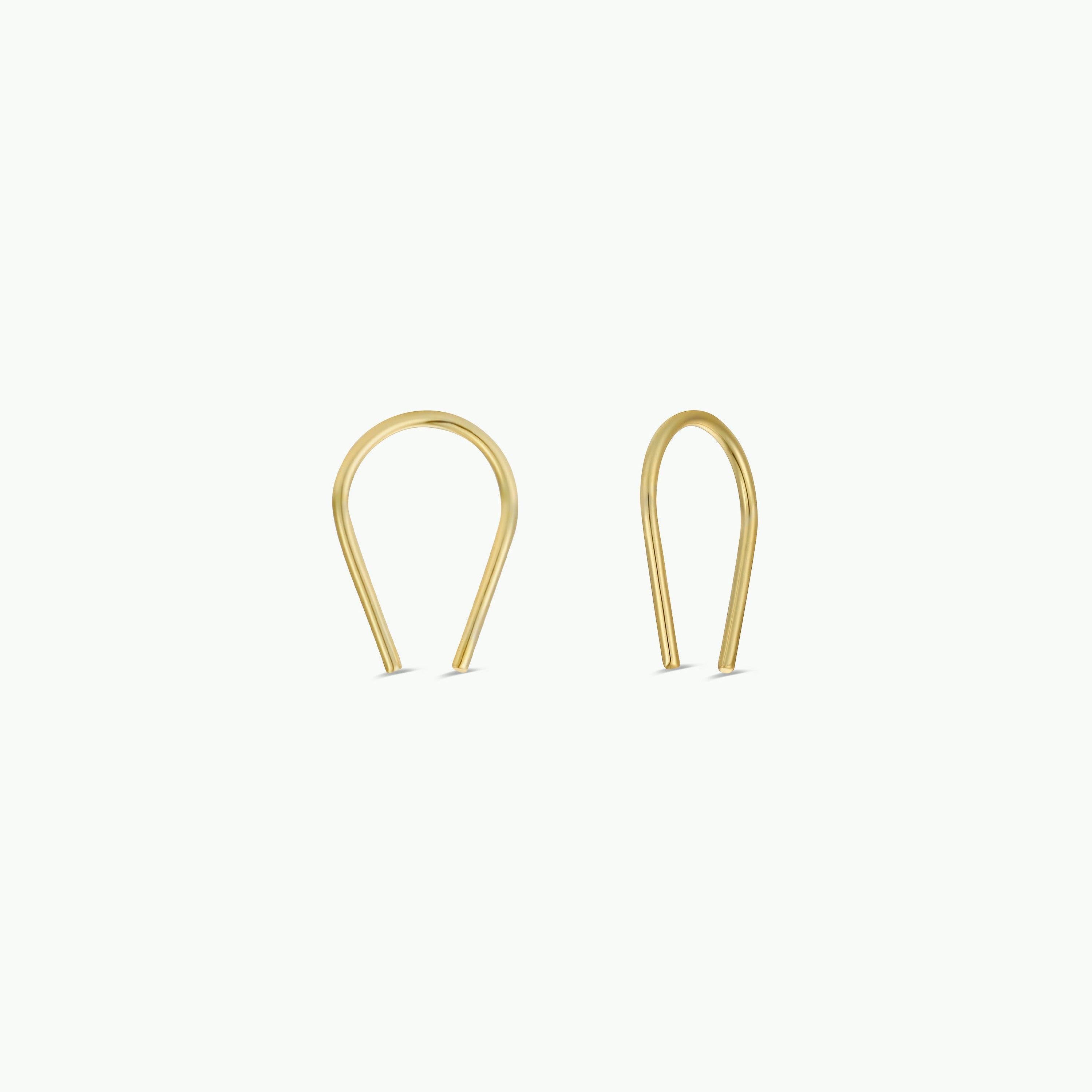 Two Minimalist Horseshoe earrings, crafted in 18k gold plating with a sleek U-shaped design, are displayed on a plain white background.