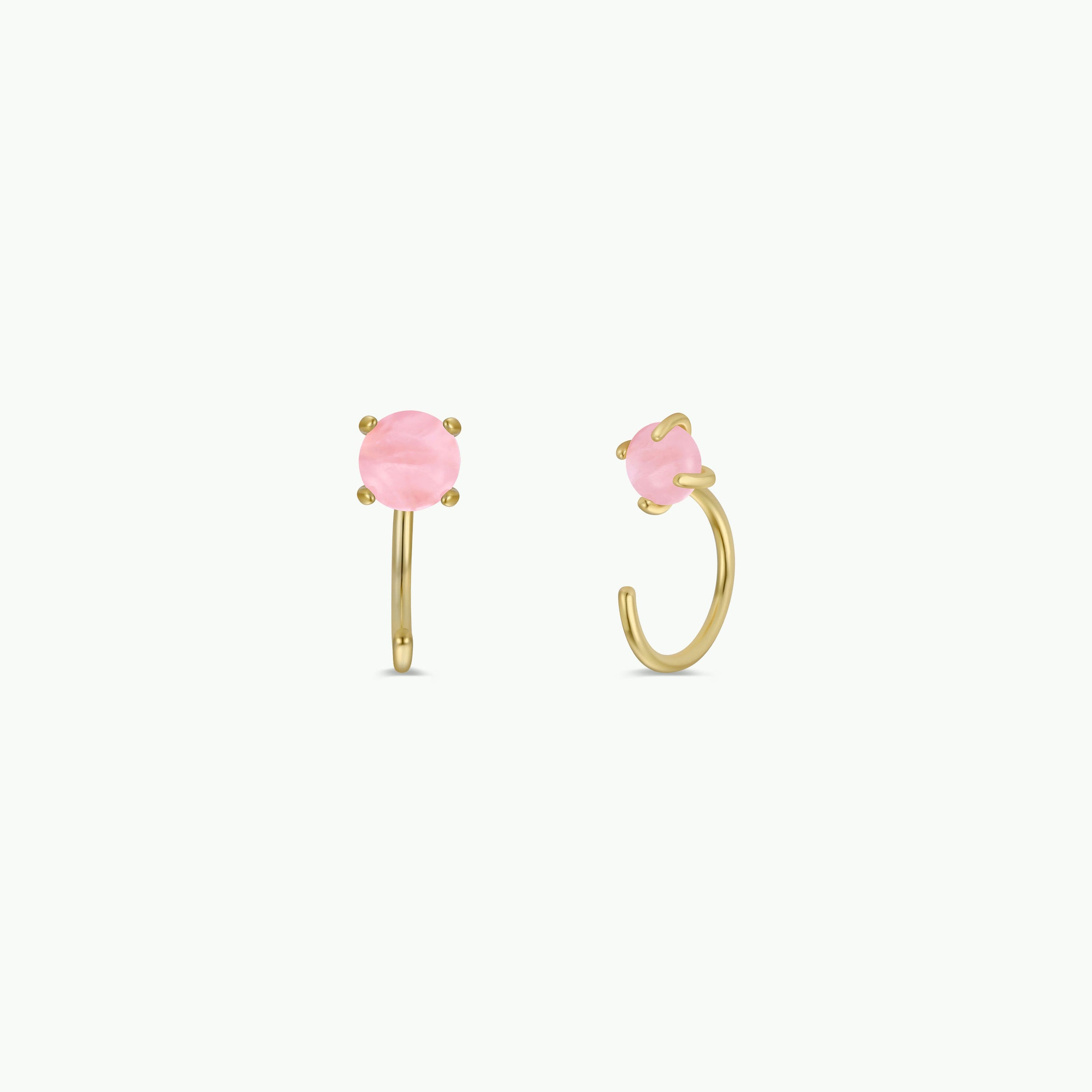 The Rose Quartz Huggie features gold huggie earrings with round, faceted rose quartz gemstones held by four prongs. Shown on a plain white background, one earring displays the front view while the other shows a side profile.