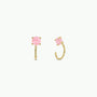 The Rose Quartz Huggie features gold huggie earrings with round, faceted rose quartz gemstones held by four prongs. Shown on a plain white background, one earring displays the front view while the other shows a side profile.