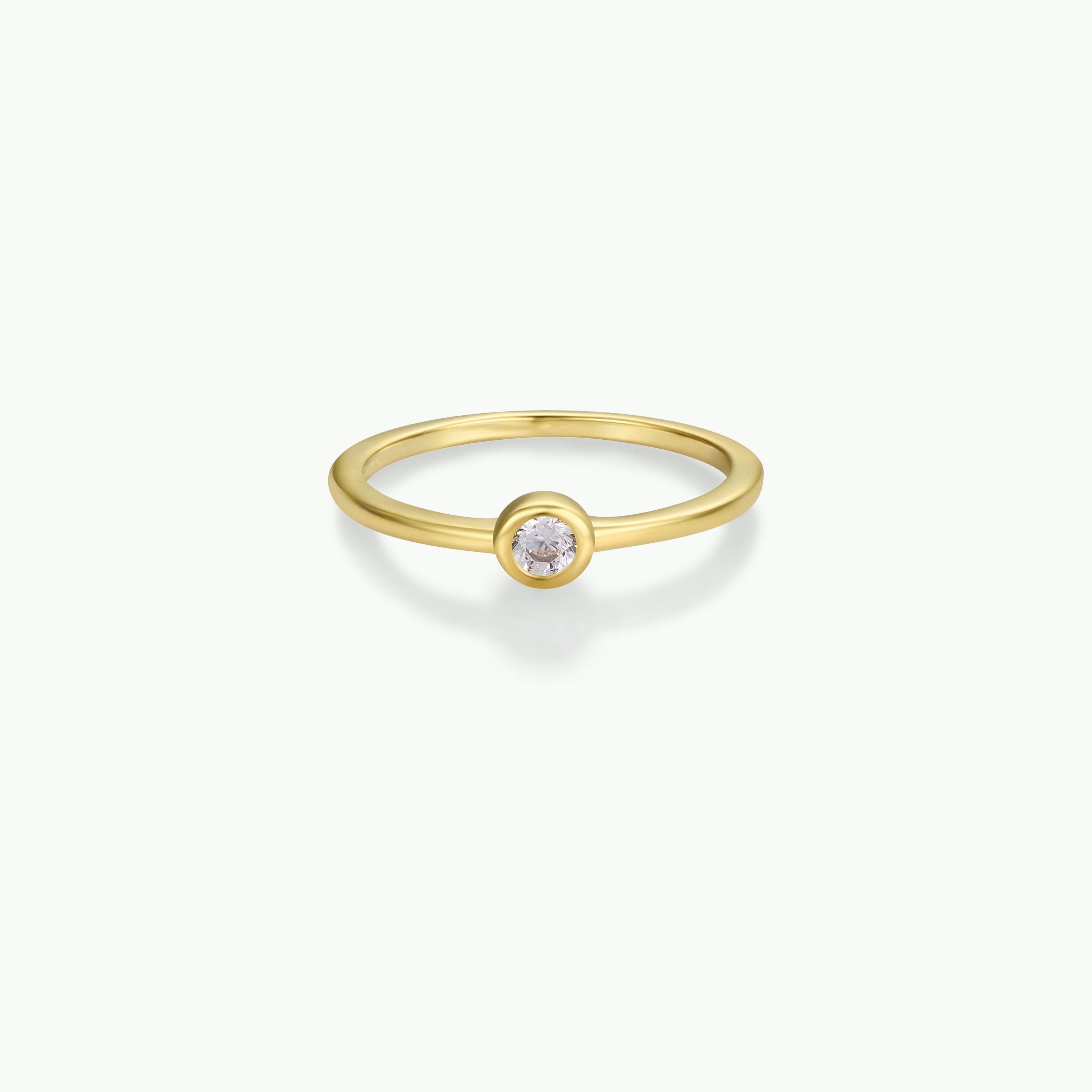 The Simple Stud Ring features a thin gold band with a single round cubic zirconia in a bezel setting, shown against a plain white background.