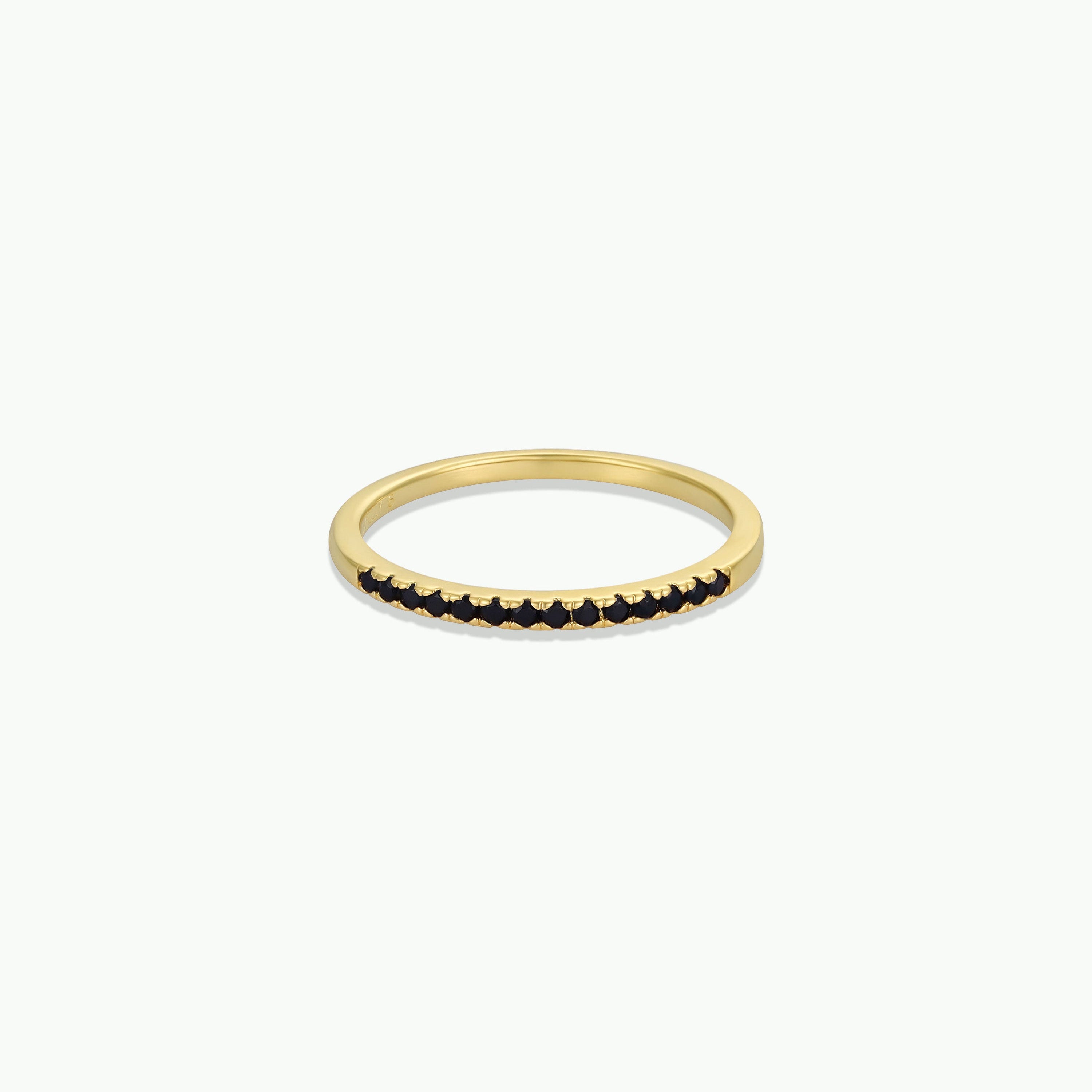 The Half Pave Ring - Black is a delicate gold band with a row of black cubic zirconia stones on top, shown against a plain white background.
