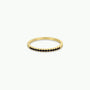 The Half Pave Ring - Black is a delicate gold band with a row of black cubic zirconia stones on top, shown against a plain white background.
