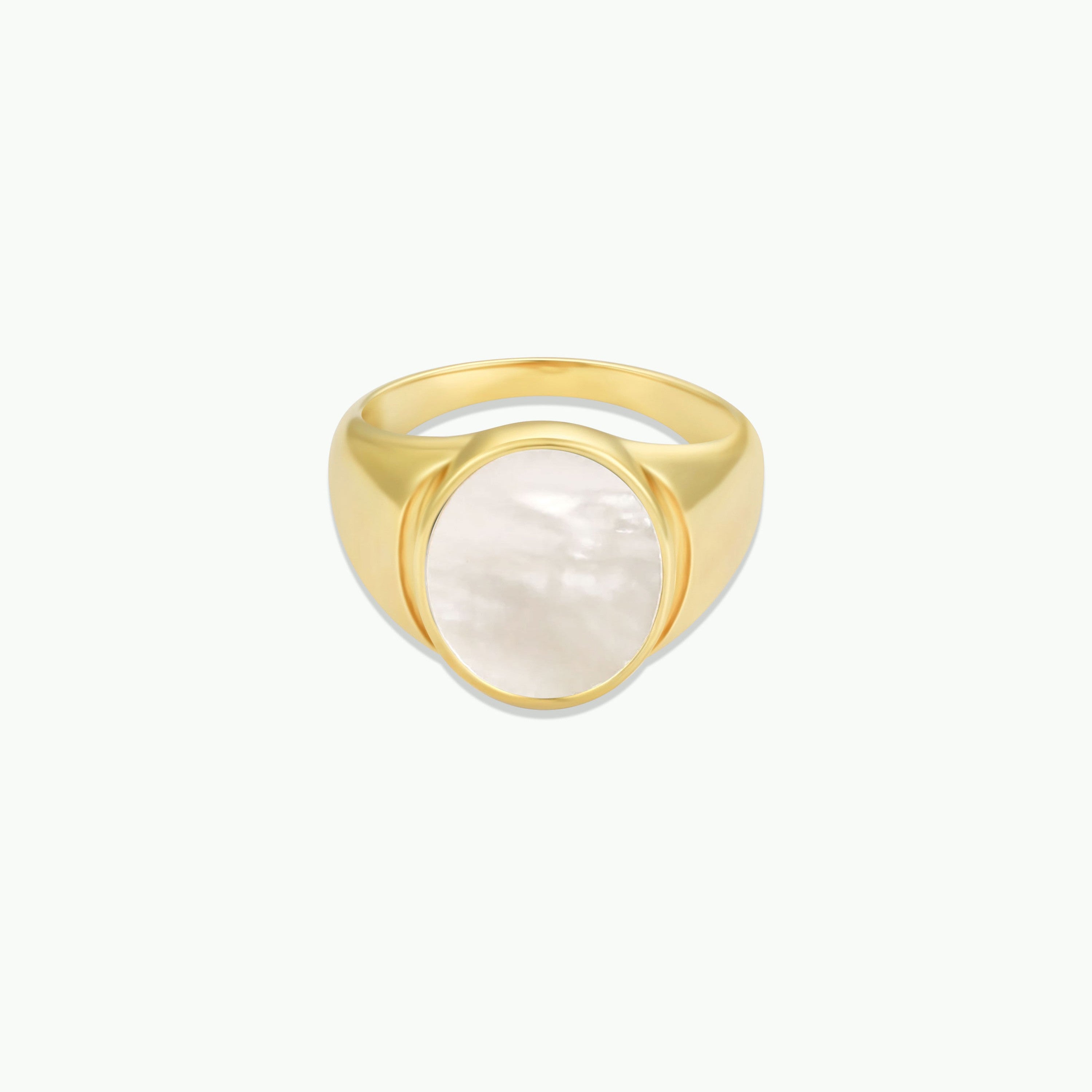 The Mother of Pearl Signet Ring features a round, glossy white mother of pearl centerpiece set in a smooth, polished gold band and is displayed against a plain white background.