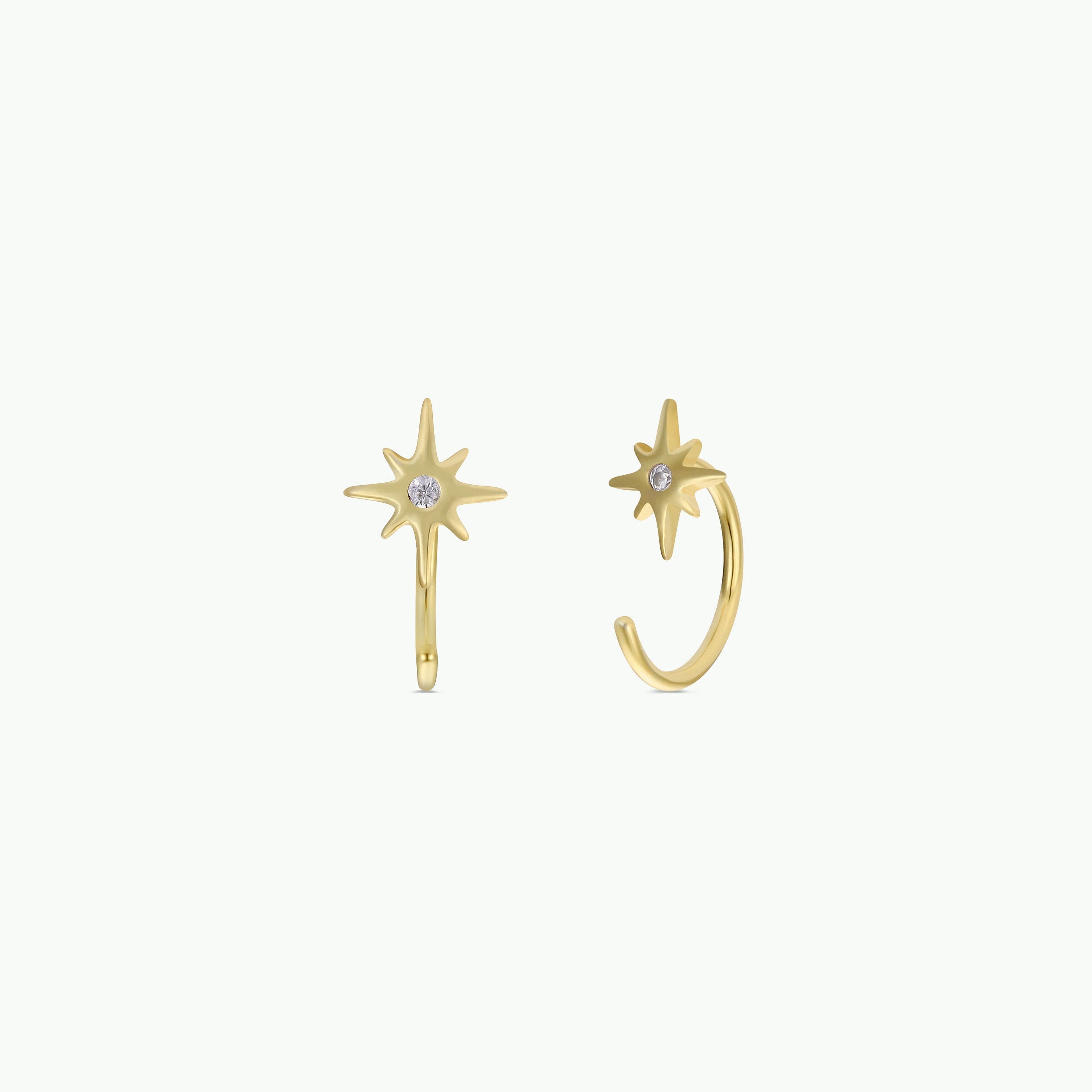 The Star Huggie earrings are 18k gold plated, star-shaped, and each features a small clear gemstone at the center, shown on a plain white background.