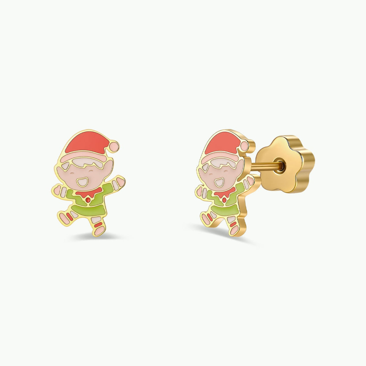 JaxKelly Elf Enamel Flat Back Kids Earrings are shown on a white background, each featuring a smiling elf in a red hat and green outfit. One earring is displayed from the front, while the other reveals the flat stud and flower-shaped back. Crafted as hypoallergenic earrings, these adorable kids’ accessories are perfect for sensitive ears.