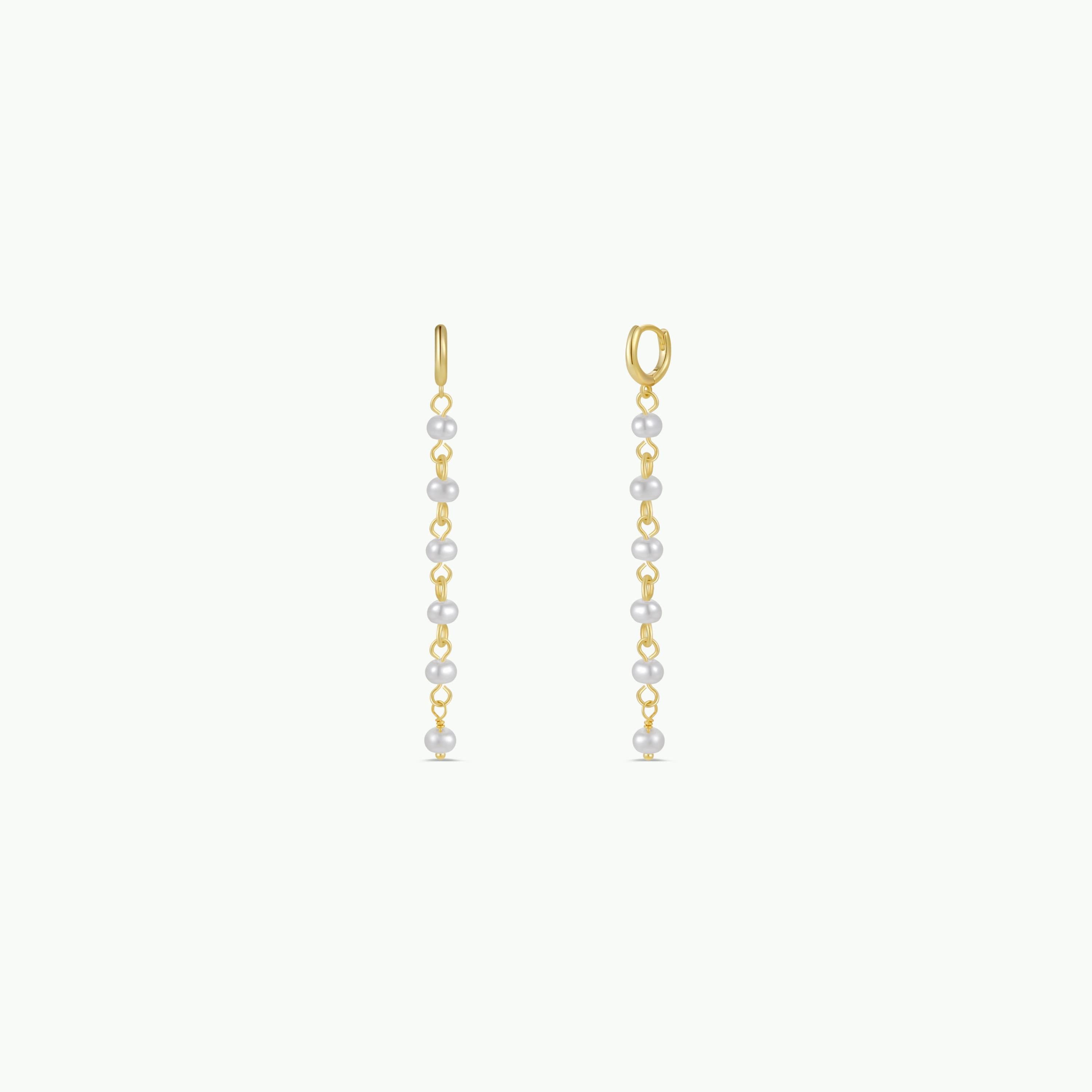The Multi Pearl Drop features 18k gold plated hoop earrings with long, delicate chains adorned with evenly spaced small white pearls—a modern twist on classic pearl drop earrings, shown on a plain white background.