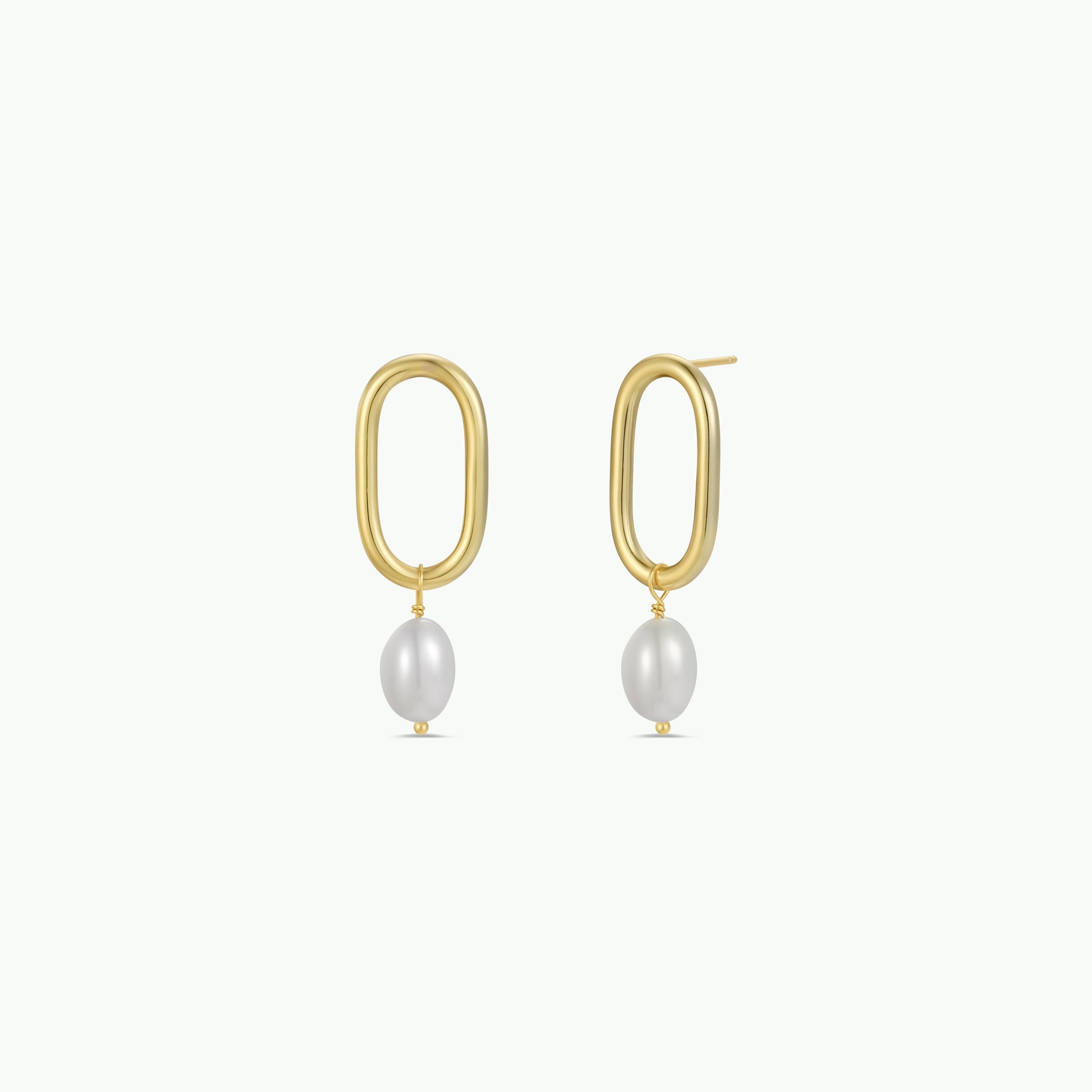 The Oval Pearl Drop features a pair of 18k gold plated elongated hoops with white pearl earrings, beautifully displayed on a plain white background.