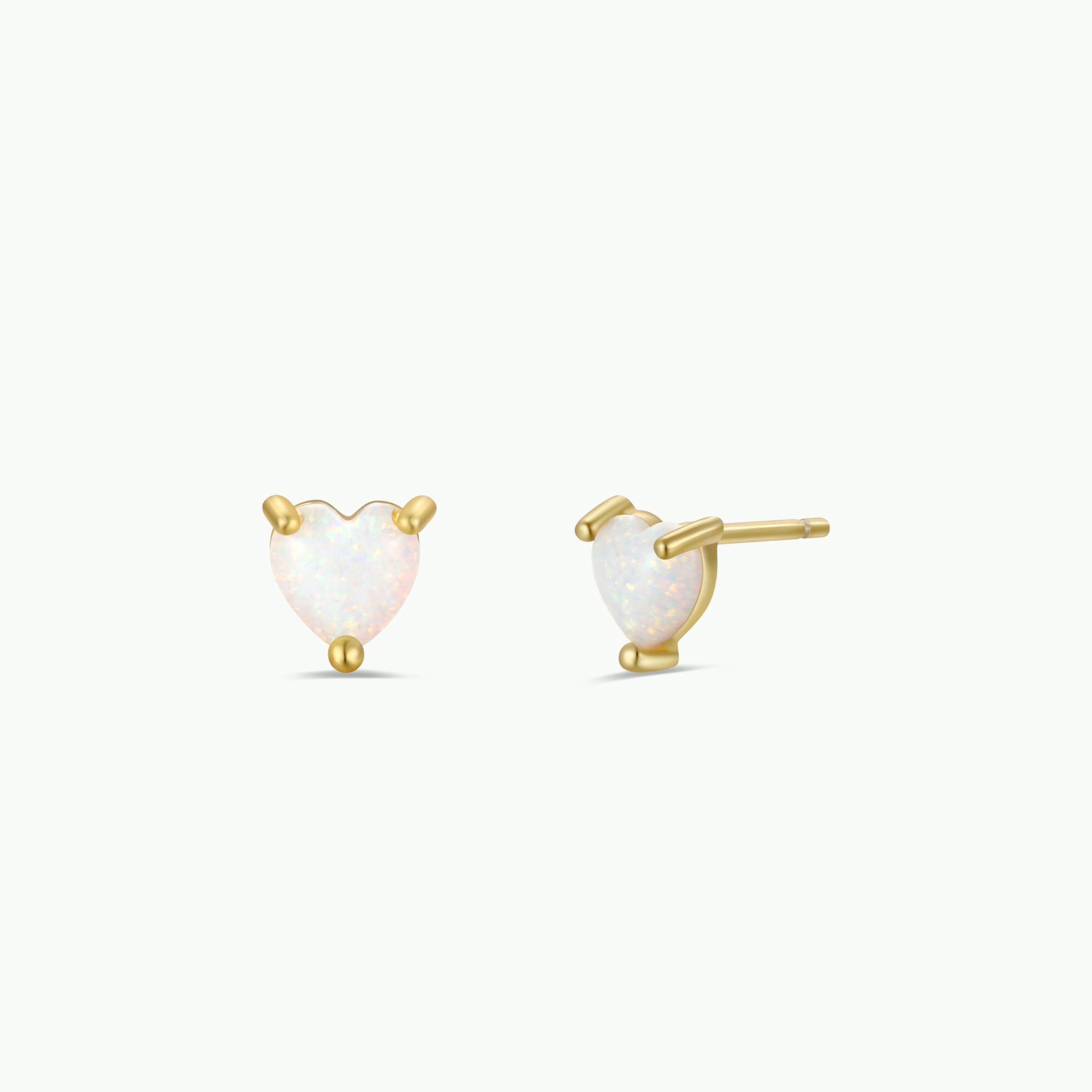 The Puffed Heart - White Opal earrings feature lab-grown opal stones in heart-shaped gold-plated prongs, displayed from the front and side on a plain white background.