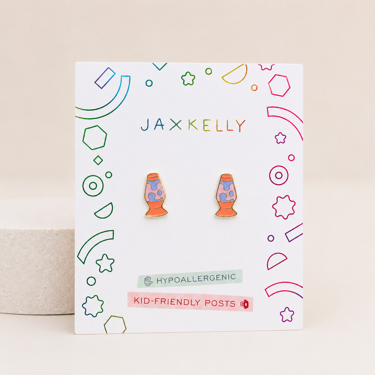 Showcased on a vibrant JaxKelly card with playful geometric accents, the Lava Lamp Enamel Flat Back Kids Earrings feature hypoallergenic and kid-friendly posts—making them a stylish, comfortable choice for sensitive ears.