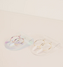 The Iridescent Earring Display Bent Large showcases two pairs of hoop earrings: iridescent hoops with crystal pendants on the left, and gold hoops with white cylindrical pendants on the right, all presented on minimalist acrylic stands.