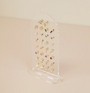 The Clear Earring Display Stud Arch offers an elegant retail display, showcasing stud earrings and small dangles in colorful and gold styles against a neutral background with its clear acrylic design.