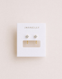 A pair of small, tarnish-free gold White CZ Huggie earrings displayed on a white card with the brand name JaxKelly printed at the top.