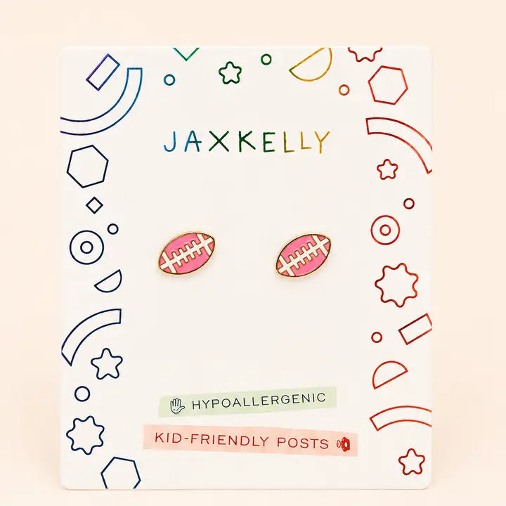 JaxKelly Football Enamel Flat Back Kids Earrings in pink and white, shaped like footballs, presented on a display card with colorful geometric shapes.