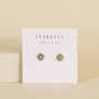 The Turquoise Sun Stud earrings feature gold sun designs with turquoise stone centers and 18k gold plating, displayed on a white JaxKelly "Wear Good Vibes" card against a beige background.