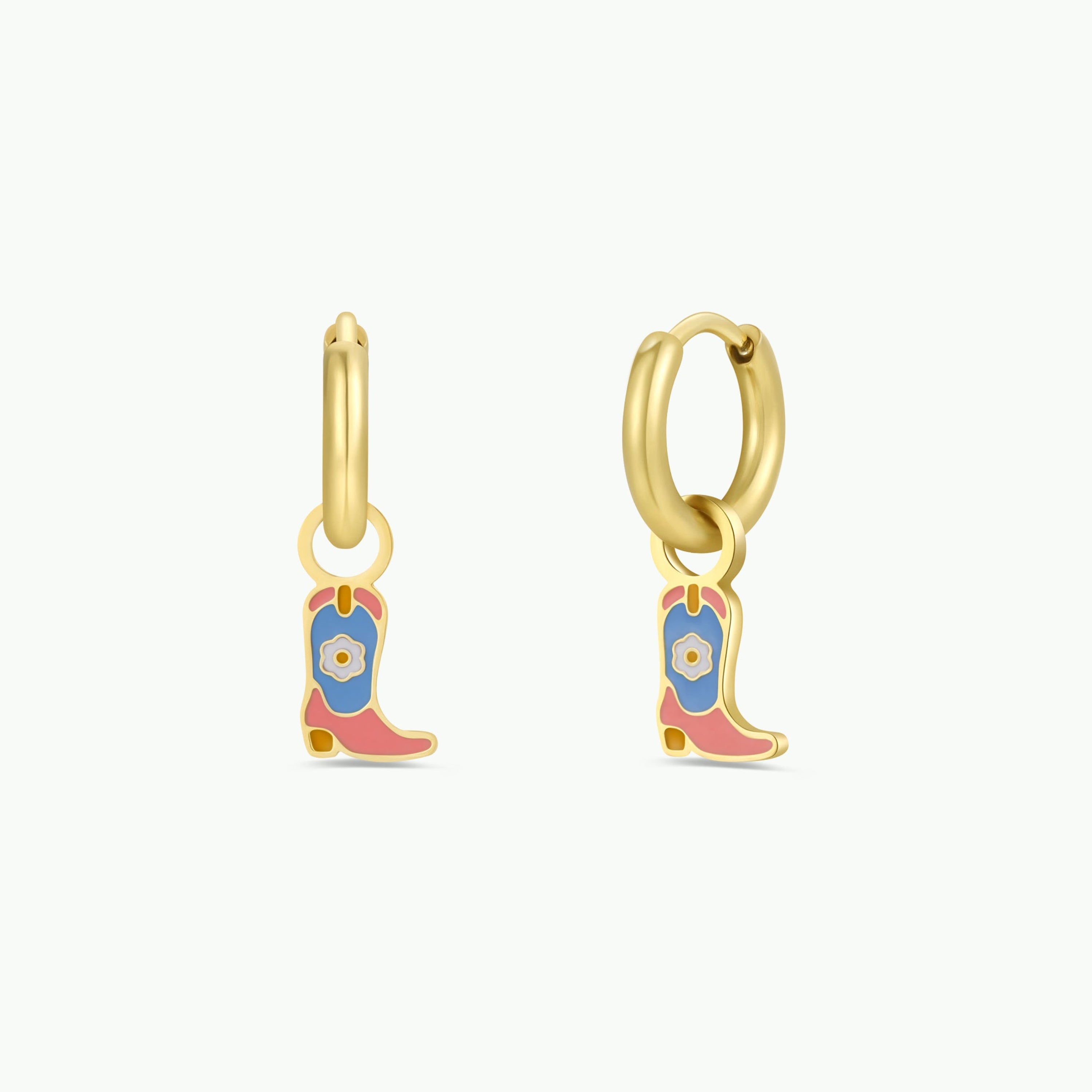 The Boot Enamel Charm Hoop features two gold hoop earrings with colorful cowboy boot charms in blue, pink, and yellow enamel. These hypoallergenic earrings are perfect for kids with sensitive ears and are displayed on a plain white background.
